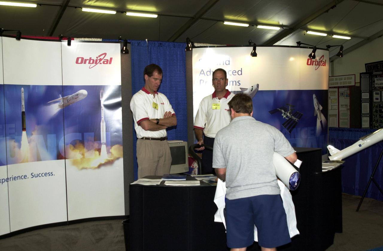KENNEDY SPACE CENTER, FLA. -- At the 2002 Space Congress, Cape Canaveral, Fla., held April 30 - May 3, a visitor stops by the Orbital Sciences display booth. The Space Congress is held annually to highlight military and space initiatives, new technologies, and Florida's role in programs and research. This year's theme is Beginning a New Era - Initiatives in Space. NASA presented several paper sessions, including Hubble Discoveries and Advancements in Technology. Space Congress is sponsored by the Canaveral Council of Technical Societies