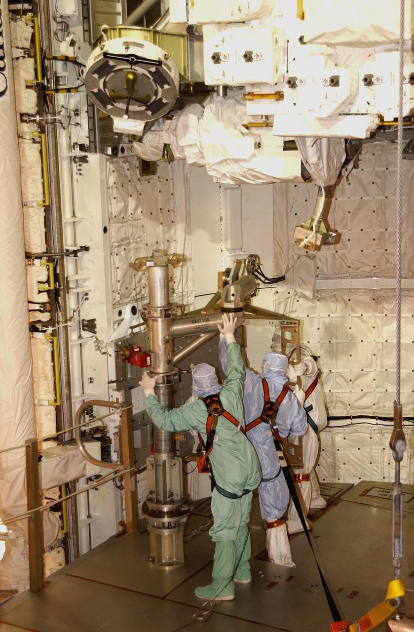 KENNEDY SPACE CENTER, FLA. -- At Pad 39A, technicians install the replacement wrist joint for the Space Station Remote Manipulator System into Space Shuttle Endeavour's payload bay. The new wrist joint, called an Orbital Replacement Unit (ORU), will be installed next to the arm's Latching End Effector during the final of three planned spacewalks. Mission STS-111 is designated UF-2, the 14th assembly flight to the International Space Station. Endeavour's payload includes the Multi-Purpose Logistics Module Leonardo and Mobile Base System. The mission also will swap resident crews on the Station, carrying the Expedition 5 crew and returning to Earth Expedition 4. Liftoff of Endeavour is scheduled between 4 and 8 p.m. May 30, 2002
