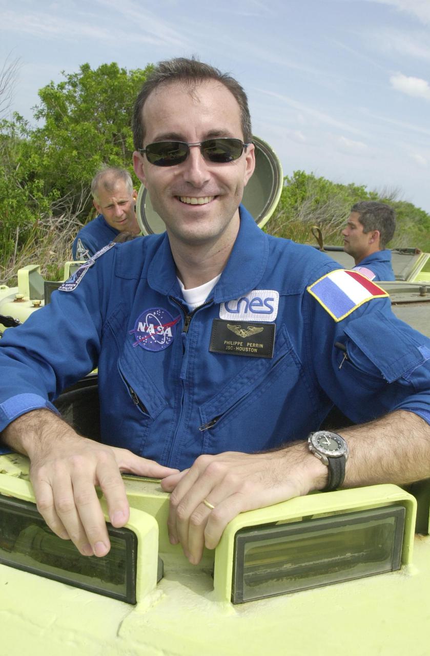 KENNEDY SPACE CENTER, FLA. -- STS-111 Mission Specialist Philippe Perrin, with the French Space Agency, poses for the camera before taking his turn at driving the M-113 armored personnel carrier during emergency egress training at the pad. Behind him are Commander Kenneth Cockrell (left) and Pilot Paul Lockhart (right). The training is part of Terminal Countdown Demonstration Test activities at KSC. The TCDT also includes a simulated launch countdown. Known as Utilization Flight -2, the mission includes attaching a Canadian-built mobile base system to the International Space Station that will enable the Canadarm2 robotic arm to move along a railway on the Station's truss to build and maintain the outpost. The crew will also replace a faulty wrist_roll joint on the Canadarm2 as well as unload almost three tons of experiments and supplies from the Italian-built Multi-Purpose Logistics Module Leonardo. Launch of Space Shuttle Endeavour on mission STS-111 is scheduled for May 30, 2002