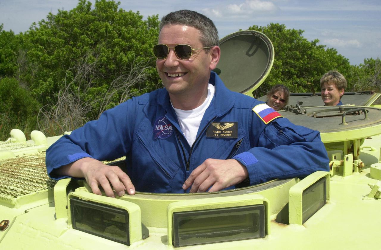 KENNEDY SPACE CENTER, FLA. - During Terminal Countdown Demonstration Test activities at KSC, Expedition 5 Commander Valeri Korzun smiles for a photo before climbing inside the M-113 armored personnel carrier, used for emergency egress training at the pad. Passengers in the vehicle are (left) astronaut Tracy Caldwell, a mission specialist candidate currently assigned to the Astronaut Office Space Station Operations Branch, and Expedition 5 member Peggy Whitson. Expedition 5 will travel to the International Space Station on mission STS-111 as the replacement crew for Expedition 4, who will return to Earth aboard Endeavour. The TCDT also includes a simulated launch countdown Known as Utilization Flight -2, the mission includes attaching a Canadian-built mobile base system to the International Space Station that will enable the Canadarm2 robotic arm to move along a railway on the Station's truss to build and maintain the outpost. The crew will also replace a faulty wrist_roll joint on the Canadarm2 as well as unload almost three tons of experiments and supplies from the Italian-built Multi-Purpose Logistics Module Leonardo. Launch of Space Shuttle Endeavour on mission STS-111 is scheduled for May 30, 2002