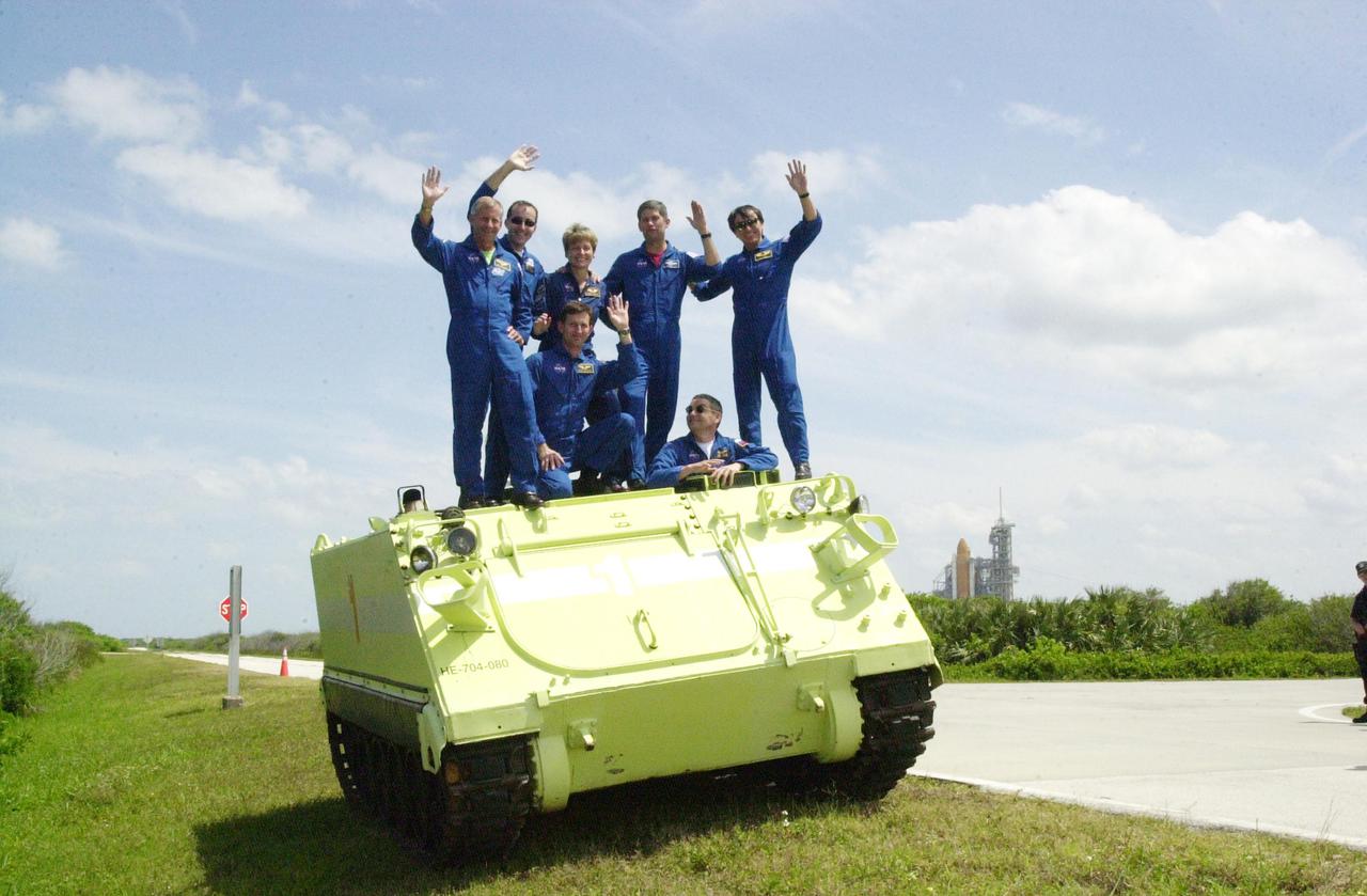 KENNEDY SPACE CENTER, FLA. -- Gathered on top of the M-113 armored personnel carrier they practiced driving during emergency egress training at the pad , the STS-11 and Expedition 5 crews wave at the camera. Standing, left to right, are Mission Commander Kenneth Cockrell, Mission Specialist Philippe Perrin, Expedition 5 member Peggy Whitson, Pilot Paul Lockhart and Mission Specialist Franklin Chang-Diaz; in front are Expedition 5 members Sergei Treschev (left) and Commander Valeri Korzun (right). The crews are taking part in Terminal Countdown Demonstration Test activities at KSC, which include a simulated launch countdown. Expedition 5 will travel to the International Space Station on mission STS-111 as the replacement crew for Expedition 4, who will return to Earth aboard Endeavour. Known as Utilization Flight -2, the mission includes attaching a Canadian-built mobile base system to the International Space Station that will enable the Canadarm2 robotic arm to move along a railway on the Station's truss to build and maintain the outpost. The crew will also replace a faulty wrist_roll joint on the Canadarm2 as well as unload almost three tons of experiments and supplies from the Italian-built Multi-Purpose Logistics Module Leonardo. Launch of Space Shuttle Endeavour on mission STS-111 is scheduled for May 30, 2002
