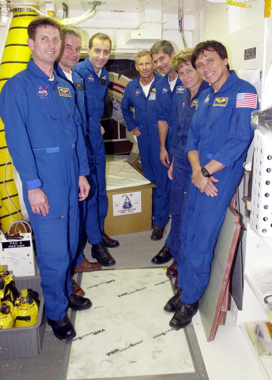 KENNEDY SPACE CENTER, FLA. --  In the White Room, Launch Pad 39A, the STS-111 and Expedition 5 crews pose in front of the entry into Space Shuttle Endeavour.  From left are Expedition 5 crew member Sergei Treschev and Commander Valeri Korzun, with the Russian Space Agency; STS-111 Mission Specialist Philippe Perrin, with the French Space Agency; Commander Kenneth Cockrell and Pilot Paul Lockhart; Expedition 5 crew member Peggy Whitson; and Mission Specialist Franklin Chang-Diaz.  The crews are taking part in Terminal Countdown Demonstration Test activities at the pad, which include emergency egress training and a simulated launch countdown.  The mission is Utilization Flight 2, carrying supplies and equipment to the International Space Station, the Mobile Base System, which will be installed on the Mobile Transporter to complete the Canadian Mobile Servicing System, or MSS, and a replacement wrist_roll joint for Canadarm 2. The mechanical arm will then have the capability to 'inchworm' from the U.S. Lab Destiny to the MSS and travel along the truss to work sites.   Expedition 5 will travel to the Station on Endeavour as the replacement crew for Expedition 4, who will return to Earth aboard the orbiter.  Launch is scheduled for May 30, 2002