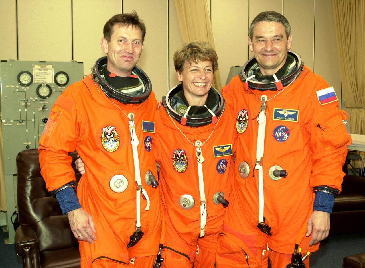 KENNEDY SPACE CENTER, FLA. - The Expedition 5 crew pauses during suitup before going to the pad for a simulated launch countdown, part of Terminal Countdown Demonstration Test activities. From left are cosmonaut Sergei Treschev, astronaut Peggy Whitson and Commander Valeri Korzun. . Expedition 5 will travel to the International Space Station on mission STS-111 as the replacement crew for Expedition 4, who will return to Earth aboard Endeavour. Mission STS-111 is known as Utilization Flight 2, carrying supplies and equipment in the Multi-Purpose Logistics Module Leonardo to the Station. The payload also includes the Mobile Base System, which will be installed on the Mobile Transporter to complete the Canadian Mobile Servicing System, or MSS, and a replacement wrist_roll joint for Canadarm 2. The mechanical arm will then have the capability to 'inchworm' from the U.S. Lab Destiny to the MSS and travel along the truss to work sites. Launch is scheduled for May 30, 2002
