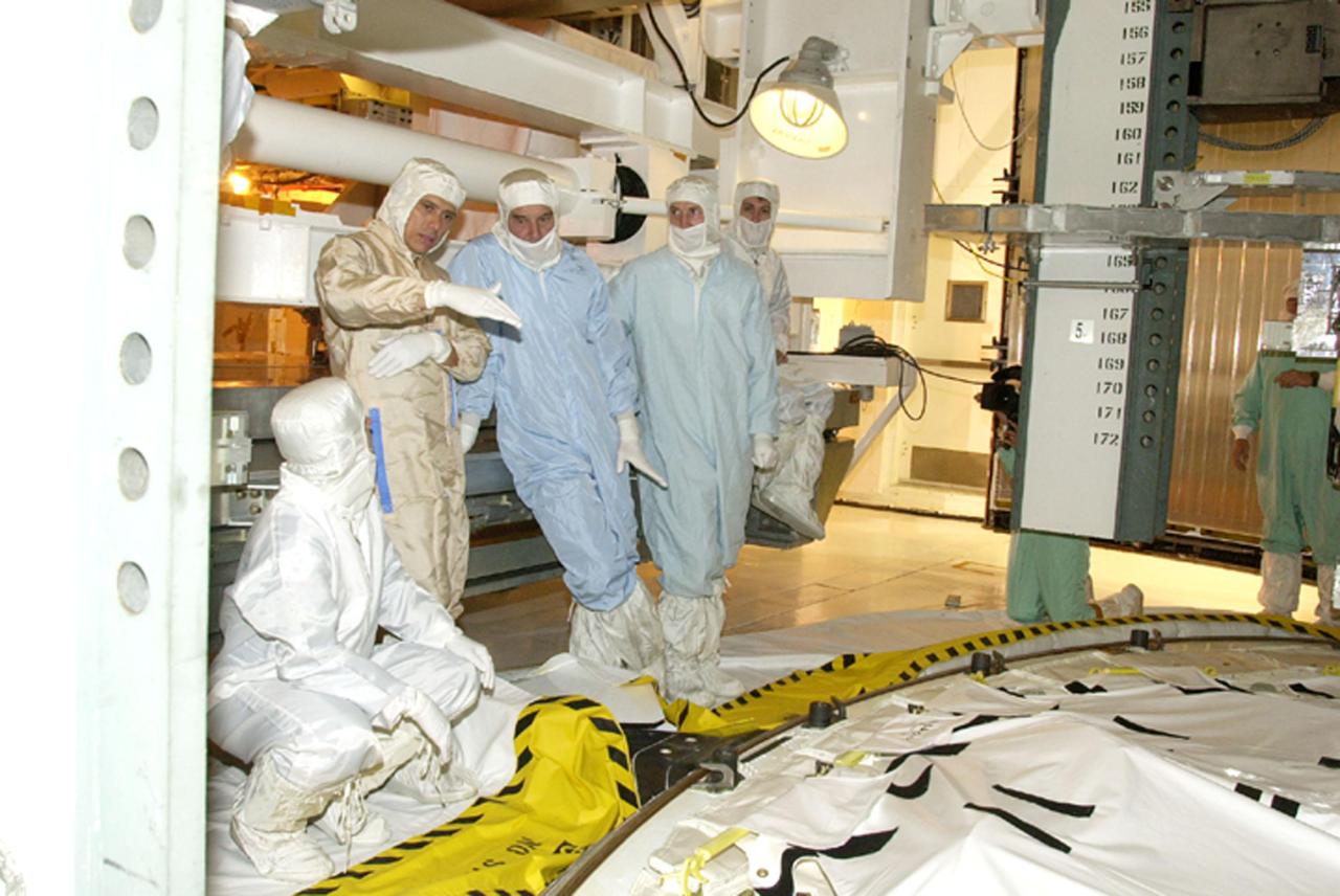 KENNEDY SPACE CENTER, FLA. -- In the Orbiter Processing Facility, members of the STS-111 and Expedition 5 crews look over the payload. installed in Endeavour's payload bay.  From left are Mission Specialists Philippe Perrin (kneeling) and Franklin Chang-Diaz, and Expedition 5 Commander Valeri Korzun, Sergei Treschev and Peggy Whitson.  Perrin with the French Space Agency; Korzun and Treschev are with the Russian Space Agency.  The crews are at KSC for Terminal Countdown Demonstration Test activities, which include payload familiarization and a simulated launch countdown. The mission crew also includes Commander Kenneth Cockrell and Pilot Paul Lockhart. The payload on the mission to the International Space Station includes the Mobile Base System, an Orbital Replacement Unit and Multi-Purpose Logistics Module Leonardo.  The Expedition 5 crew is traveling on Endeavour to replace the Expedition 4 crew on the Station.  Launch of Endeavour is scheduled for May 30, 2002. 