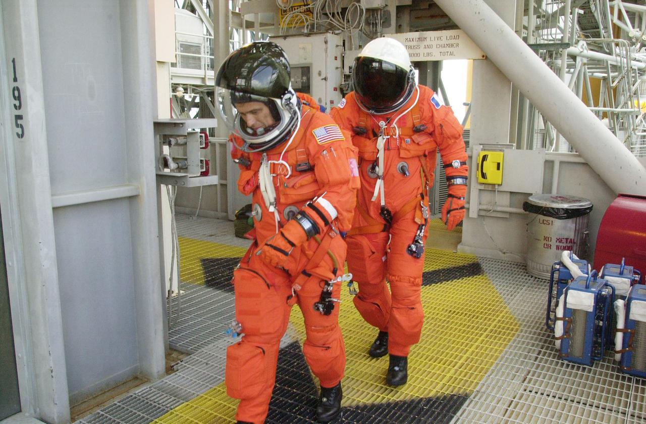 KENNEDY SPACE CENTER, FLA. -- On Launch Pad 39A, STS-111 Mission Specialists Franklin Chang-Diaz and Philippe Perrin practice making a hasty exit from the 195-foot level to the slidewire baskets in the event of an emergency.  Perrin is with the French Space Agency.  They and the rest of the STS-111 crew and Expedition 5 crew are taking part in Terminal Countdown Demonstration Test activities, which include emergency egress training and a simulated launch countdown.  Mission STS-111 is Utilization Flight 2, carrying equipment and supplies in the Multi-Purpose Logistics Module Leonardo to the International Space Station, plus the Mobile Base System (MBA) and an Orbital Replacement Unit.  The MBS will be installed on the Mobile Transporter to complete the Canadian Mobile Servicing System, or MSS, enabling Canadarm 2 to 'inchworm' from the U.S. Lab Destiny to the MSS and travel along the truss to work sites.  The Expedition 5 crew is traveling on Endeavour to replace the Expedition 4 crew on the Station.  Launch of Endeavour is scheduled for May 30, 2002