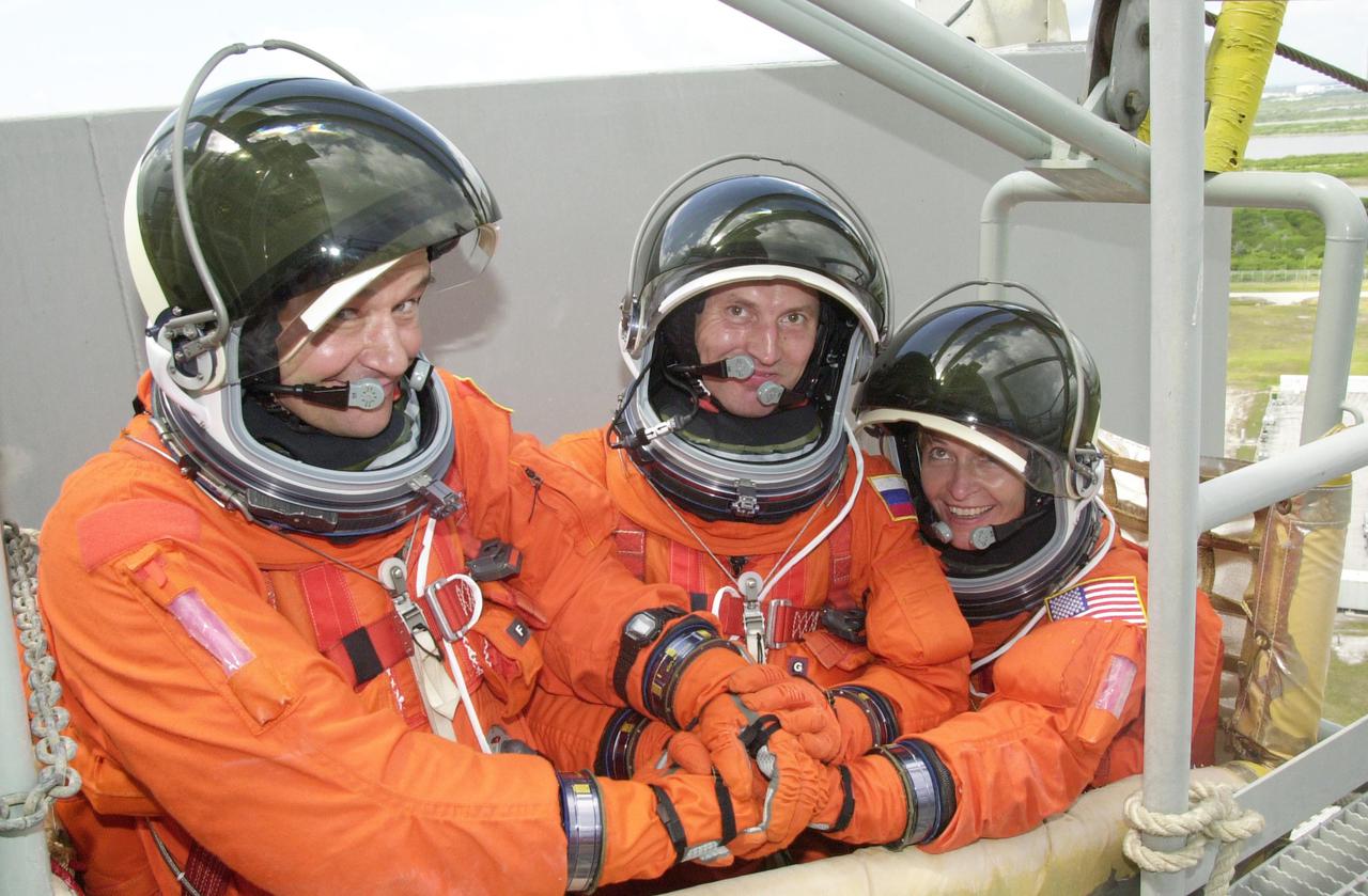KENNEDY SPACE CENTER, FLA. - The Expedition 5 crew - Commander Valeri Korzun (left), Sergei Treschev (center) and Peggy Whitson (right) - are in the slidewire basket and ready to exit the Fixed Service Structure on Launch Pad 39A. They and the STS-111 crew are taking part in Terminal Countdown Demonstration Test activities, which include emergency egress training and a simulated launch countdown. Mission STS-111 is Utilization Flight 2, carrying equipment and supplies in the Multi-Purpose Logistics Module Leonardo to the International Space Station, plus the Mobile Base System (MBA) and an Orbital Replacement Unit. The MBS will be installed on the Mobile Transporter to complete the Canadian Mobile Servicing System, or MSS, enabling Canadarm 2 to 'inchworm' from the U.S. Lab Destiny to the MSS and travel along the truss to work sites. The Expedition 5 crew is traveling on Endeavour to replace the Expedition 4 crew on the Station. Launch of Endeavour is scheduled for May 30, 2002