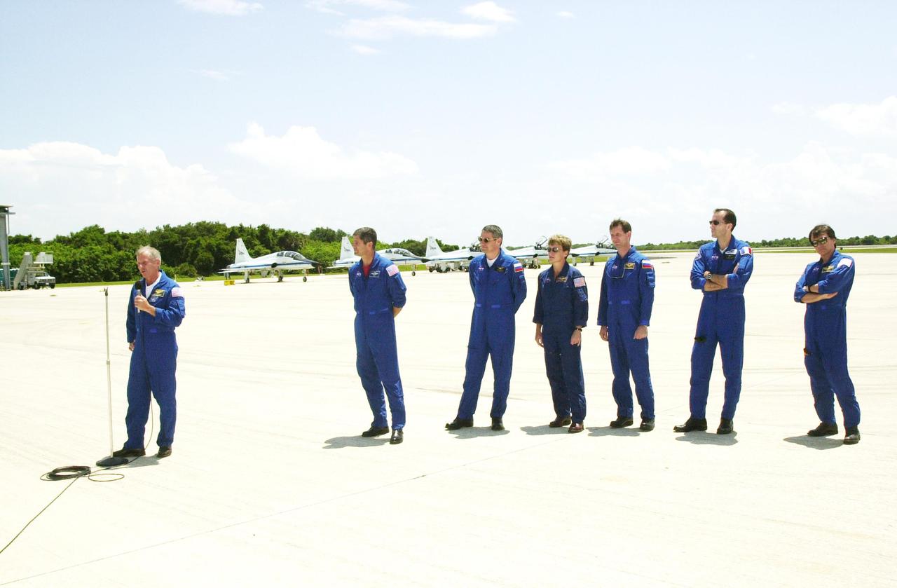 KENNEDY SPACE CENTER, FLA. -- Before leaving KSC, the STS-111 crew and Expedition 5 crew stop to talk to media at the Shuttle Landing Facility. At the microphone is Commander Kenneth Cockrell. Behind him, left to right, are Pilot Paul Lockhart; Expedition 5's Commander Valeri Korzun, astronaut Peggy Whitson and cosmonaut Sergei Treschev; Mission Specialists Philippe Perrin and Franklin Chang-Diaz. Perrin is with the French Space Agency; Korzun and Treschev are with the Russian Space Agency. The crews have been taking part in Terminal Countdown Demonstration Test activities that include emergency egress training and a simulated launch countdown. Expedition 5 will travel to the International Space Station on mission STS-111 as the replacement crew for Expedition 4, who will return to Earth aboard the orbiter. Mission STS-111 is known as Utilization Flight 2, carrying supplies and equipment in the Multi-Purpose Logistics Module Leonardo to the International Space Station. The payload also includes the Mobile Base System, which will be installed on the Mobile Transporter to complete the Canadian Mobile Servicing System, or MSS, and a replacement wrist_roll joint for Canadarm 2. The mechanical arm will then have the capability to 'inchworm' from the U.S. Lab Destiny to the MSS and travel along the truss to work sites. Launch is scheduled for May 30, 2002