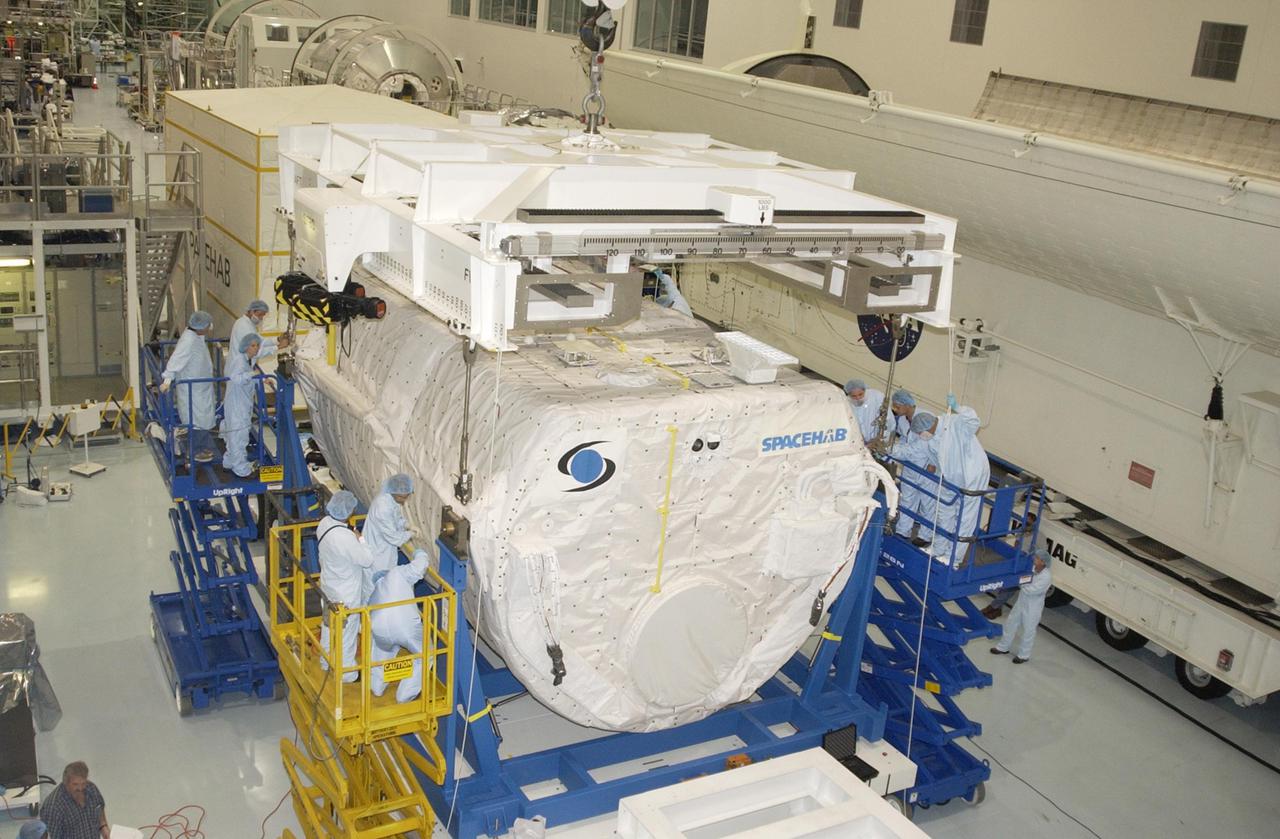KENNEDY SPACE CENTER, FLA. - In the Space Station Processing Facility, the overhead crane lifts the SHI Research Double Module (SHI_RDM) from its workstand. The module is being transferred to the payload canister for transport to the Orbiter Processing Facility where it will be installed in Columbia's payload bay for mission STS-107. SHI_RDM is the primary payload of the research mission, with experiments ranging from material sciences to life sciences (many rats).  Also part of the payload is the Fast Reaction Experiments Enabling Science, Technology, Applications and Research (FREESTAR) that incorporates eight high priority secondary attached shuttle experiments.  STS-107 is scheduled to launch July 19, 2002