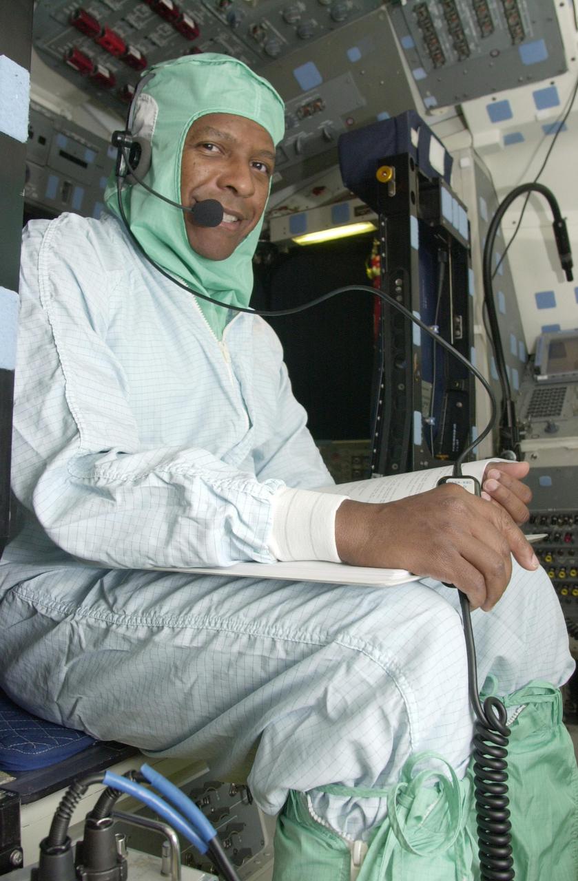 KENNEDY SPACE CENTER, FLA. - Dressed in a bunny suit, STS-107 Payload Commander Michael Anderson reviews data in Columbia's payload bay for Fast Reaction Experiments Enabling Science, Technology, Applications and Research (FREESTAR) experiments for the mission. FREESTAR comprises Mediterranean Israeli Dust, Solar Constant, Shuttle Ozone Limb Sounding, Critical Viscosity of Xenon,  Low Power, and Space Experimental Module experiments.  Another payload is the SHI Research Double Module (SHI_RDM), also known as SPACEHAB. The experiments range from material sciences to life sciences.  STS-107 is scheduled to launch July 11, 2002