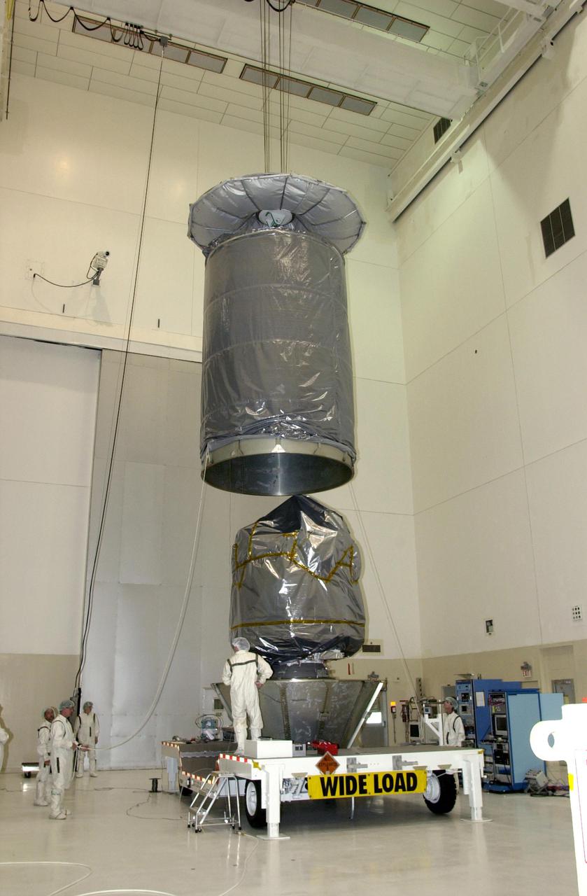KENNEDY SPACE CENTER, FLA. -- In the Space Assembly and Encapsulation Facility 2 (SAEF-2), a container is lowered toward the Comet Nucleus Tour (CONTOUR) spacecraft below. CONTOUR will be enclosed in the container for transfer to the launch pad. CONTOUR will provide the first detailed look into the heart of a comet -- the nucleus. Flying as close as 60 miles (100 kilometers) to at least two comets, the spacecraft will take the sharpest pictures yet of a nucleus while analyzing the gas and dust that surround these rocky, icy building blocks of the solar system. Launch of CONTOUR aboard a Boeing Delta II rocket is scheduled for July 1, 2002, from Launch Complex 17-A, Cape Canaveral Air Force Station