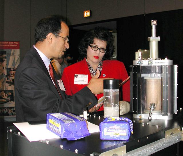 Khalid Alshibli of Louisiana State University, project scientist for the Mechanics of Granular Materials (MGM-III) experiment, explains the MGM experiment to Kristen Erickson, acting deputy associate administrator in NASA's Office of Biological and Physical Research. A training model of the test cell is at right. The activity was part of the Space Research and You education event held by NASA's Office of Biological and Physical Research on June 25, 2002, in Arlington, VA, to highlight the research that will be conducted on STS-107.