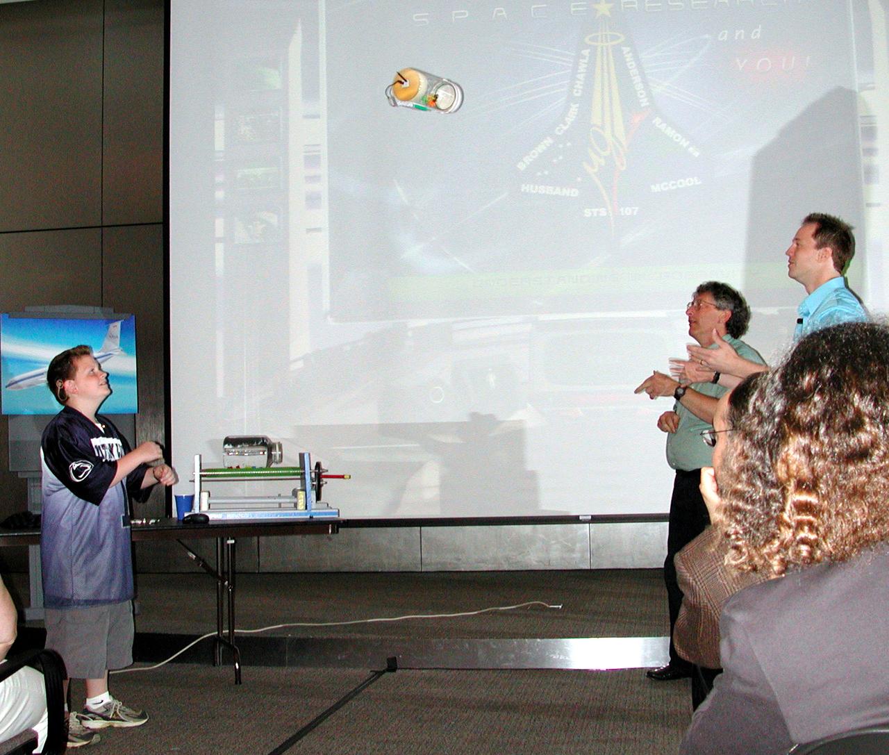 A student gets ready to catch a plastic tube carrying a small fluid bottle and a wireless video camera. As it arced through the air, the container was in free-fall -- just like astronauts in space -- and the TV camera broadcast images of how the fluid behaved. The activity was part of the Space Research and You education event held by NASA's Office of Biological and Physical Research on June 25, 2002, in Arlington, VA, to highlight the research that will be conducted on STS-107. (Digital camera image; no film original.