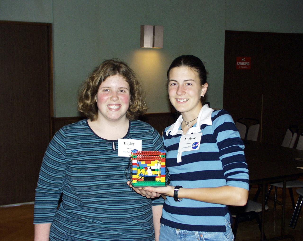 Two students show the Lego (TM) Challenge device they designed and built to operate in the portable drop tower demonstrator as part of the second Dropping in a Microgravity Environment (DIME) competition held April 23-25, 2002, at NASA's Glenn Research Center. Competitors included two teams from Sycamore High School, Cincinnati, OH, and one each from Bay High School, Bay Village, OH, and COSI Academy, Columbus, OH. DIME is part of NASA's education and outreach activities. Details are on line at http://microgravity.grc.nasa.gov/DIME_2002.html.