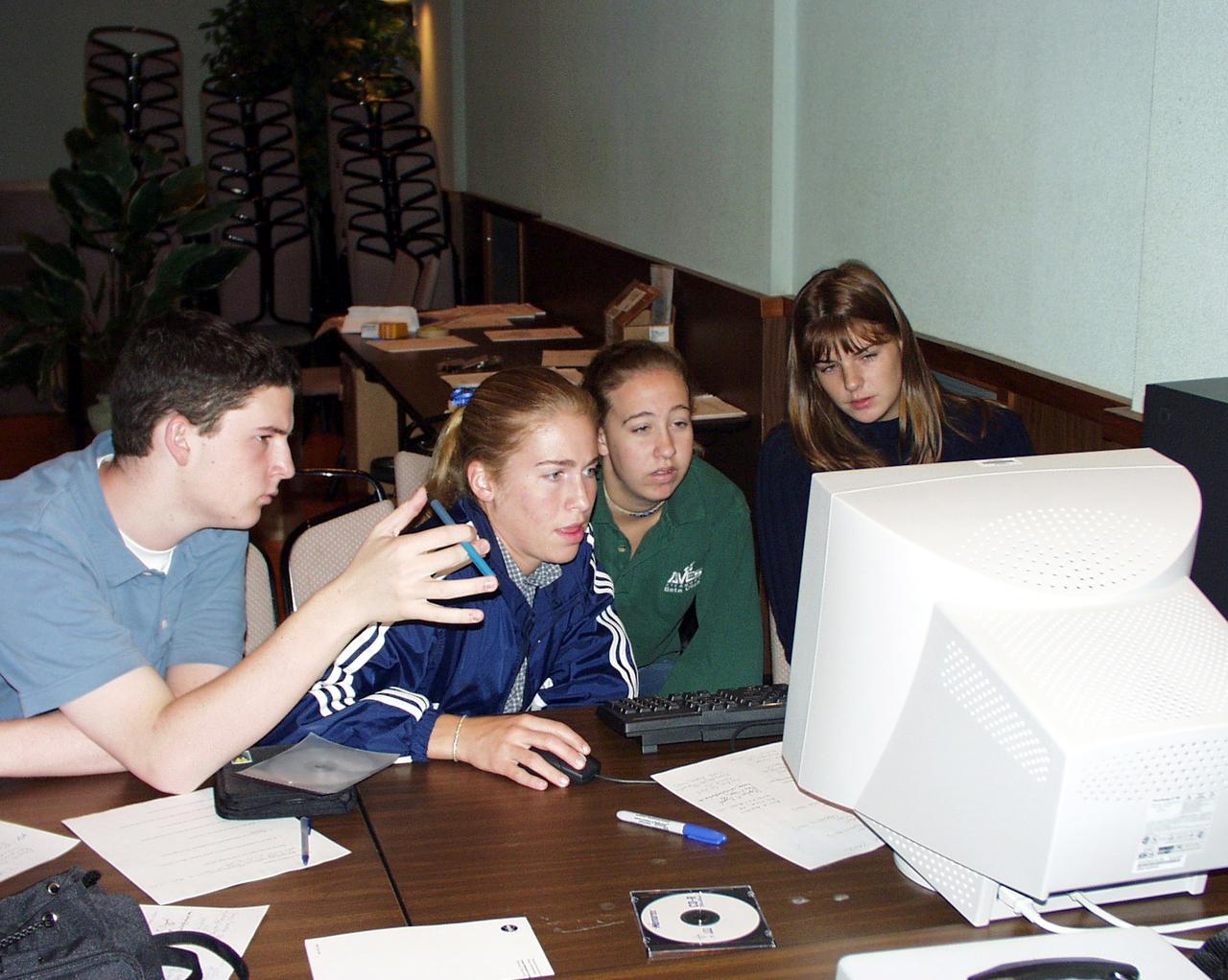 Students discuss fine points of their final design for the drop tower experiment during the second Dropping in a Microgravity Environment (DIME) competition held April 23-25, 2002, at NASA's Glenn Research Center. Competitors included two teams from Sycamore High School, Cincinnati, OH, and one each from Bay High School, Bay Village, OH, and COSI Academy, Columbus, OH. DIME is part of NASA's education and outreach activities. Details are on line at http://microgravity.grc.nasa.gov/DIME_2002.html.