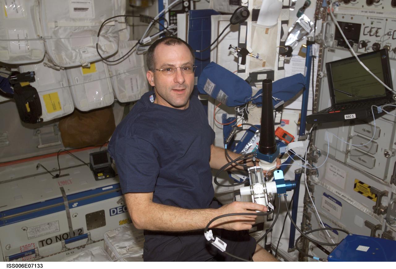 In this International Space Station (ISS) onboard photo, Expedition Six Science Officer Donald R. Pettit works to set up the Pulmonary Function in Flight (PuFF) experiment hardware in the Destiny Laboratory. Expedition Six is the fourth and final crew to perform the PuFF experiment. The PuFF experiment was developed to better understand what effects long term exposure to microgravity may have on the lungs. The focus is on measuring changes in the everness of gas exchange in the lungs, and on detecting changes in respiratory muscle strength. It allows astronauts to measure blood flow through the lungs, the ability of the lung to take up oxygen, and lung volumes. Each PuFF session includes five lung function tests, which involve breathing only cabin air. For each planned extravehicular (EVA) activity, a crew member performs a PuFF test within one week prior to the EVA. Following the EVA, those crew members perform another test to document the effect of exposure of the lungs to the low-pressure environment of the space suits. This experiment utilizes the Gas Analyzer System for Metabolic Analysis Physiology, or GASMAP, located in the Human Research Facility (HRF), along with a variety of other Puff equipment including a manual breathing valve, flow meter, pressure-flow module, pressure and volume calibration syringes, and disposable mouth pieces.