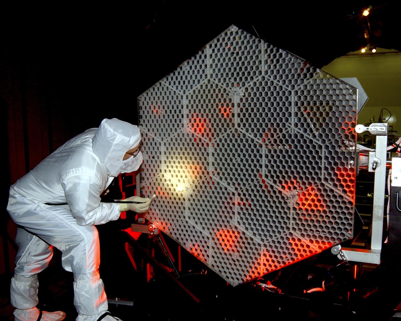 The Eastman-Kodak mirror assembly is being tested for the James Webb Space Telescope (JWST) project at the X-Ray Calibration Facility at Marshall Space Flight Center (MSFC). In this photo, an MSFC employee is inspecting one of many segments of the mirror assembly for flaws. MSFC is supporting Goddard Space Flight Center (GSFC) in developing the JWST by taking numerous measurements to predict its future performance. The tests are conducted in a vacuum chamber cooled to approximate the super cold temperatures found in space. During its 27 years of operation, the facility has performed testing in support of a wide array of projects, including the Hubble Space Telescope (HST), Solar A, Chandra technology development, Chandra High Resolution Mirror Assembly and science instruments, Constellation X-Ray Mission, and Solar X-Ray Imager, currently operating on a Geostationary Operational Environment Satellite. The JWST is NASA's next generation space telescope, a successor to the Hubble Space Telescope, named in honor of NASA's second administrator, James E. Webb. It is scheduled for launch in 2010 aboard an expendable launch vehicle. It will take about 3 months for the spacecraft to reach its destination, an orbit of 940,000 miles in space.