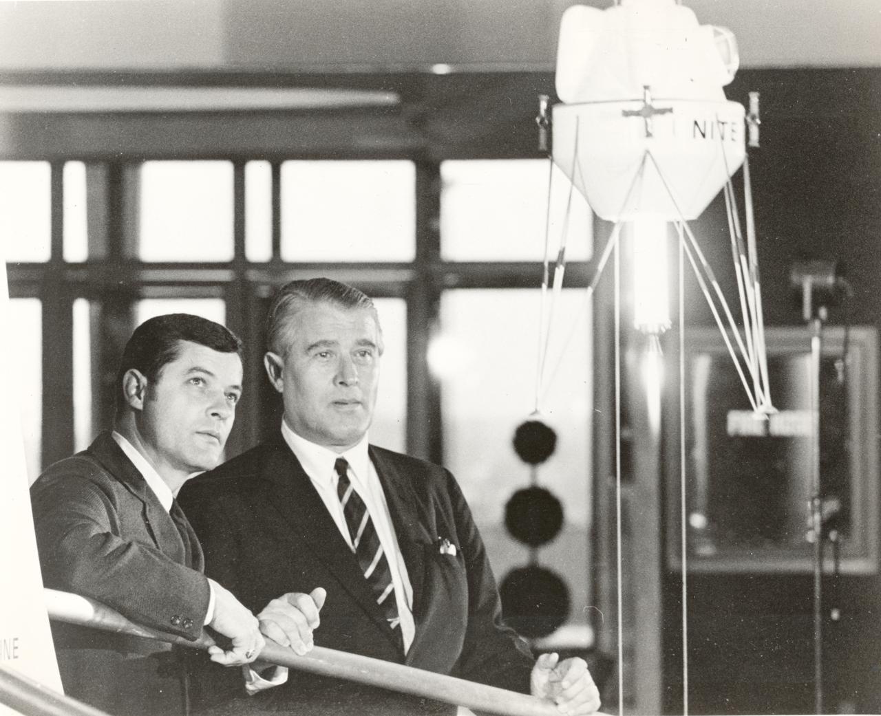 Edward O. Buckbee, the first Director of the Alabama Space Science Center (left), and Dr. Wernher von Braun (right) view a demonstration of a simulated spacecraft which uses an actual hybrid rocket engine for liftoff, hover, and landing. The display was presented to the Alabama Space Science Center, later renamed the U.S. Space and Rocket Center, by United Technology Center, a division of United Aircraft.