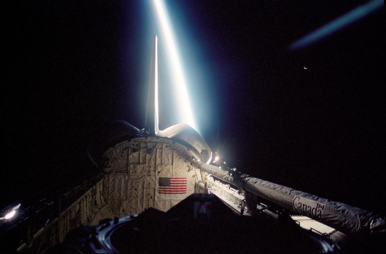 This STS-113 photograph shows an incredible view of the Space Shuttle Endeavour's payload bay. The blackness of space, Earth's moon (upper right frame), and a thin slice of Earth's horizon which runs vertically across the photograph, form the back drop for this photograph. The remote manipulator system (RMS) robotic arm is visible in lower right frame. The 16th American assembly flight and 112th overall American flight to the International Space Station (ISS) launched on November 23, 2002 from Kennedy's launch pad 39A aboard the Space Shuttle Orbiter Endeavour STS-113. Mission objectives included the installation and activation of the Port 1 Integrated Truss Assembly (P1). The first major component installed on the left side of the Station, the P1 truss provides three additional External Thermal Control System radiators. Weighing in at 27,506 pounds, the P1 truss is 45 feet (13.7 meters) long, 15 feet (4.6 meters) wide, and 13 feet (4 meters) high. Three space walks, aided by the use of the Robotic Manipulator Systems of both the Shuttle and the Station, were performed in the installation of P1.