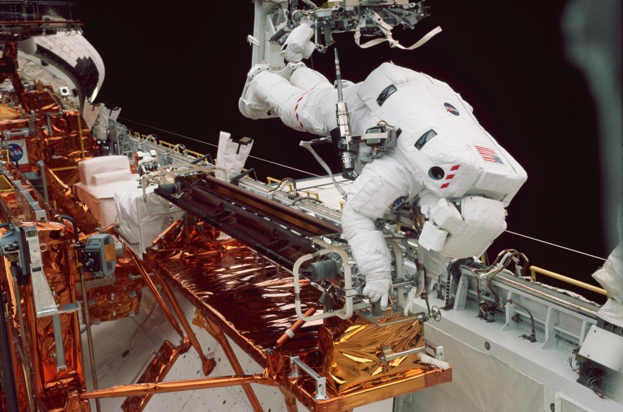 STS-109 Astronaut Michael J. Massimino, mission specialist, perched on the Shuttle's robotic arm is working at the stowage area for the Hubble Space Telescope's port side solar array. Working in tandem with James. H. Newman, Massimino removed the old port solar array and stored it in Columbia's payload bay for return to Earth. The two went on to install a third generation solar array and its associated electrical components. Two crew mates had accomplished the same feat with the starboard array on the previous day. In addition to the replacement of the solar arrays, the STS-109 crew also installed the experimental cooling system for the Hubble's Near-Infrared Camera (NICMOS), replaced the power control unit (PCU), and replaced the Faint Object Camera (FOC) with a new advanced camera for Surveys (ACS). The 108th flight overall in NASA's Space Shuttle Program, the Space Shuttle Columbia STS-109 mission lifted off March 1, 2002 for 10 days, 22 hours, and 11 minutes. Five space walks were conducted to complete the HST upgrades. The Marshall Space Flight Center in Huntsville, Alabama had the responsibility for the design, development, and construction of the HST, which is the most powerful and sophisticated telescope ever built.
