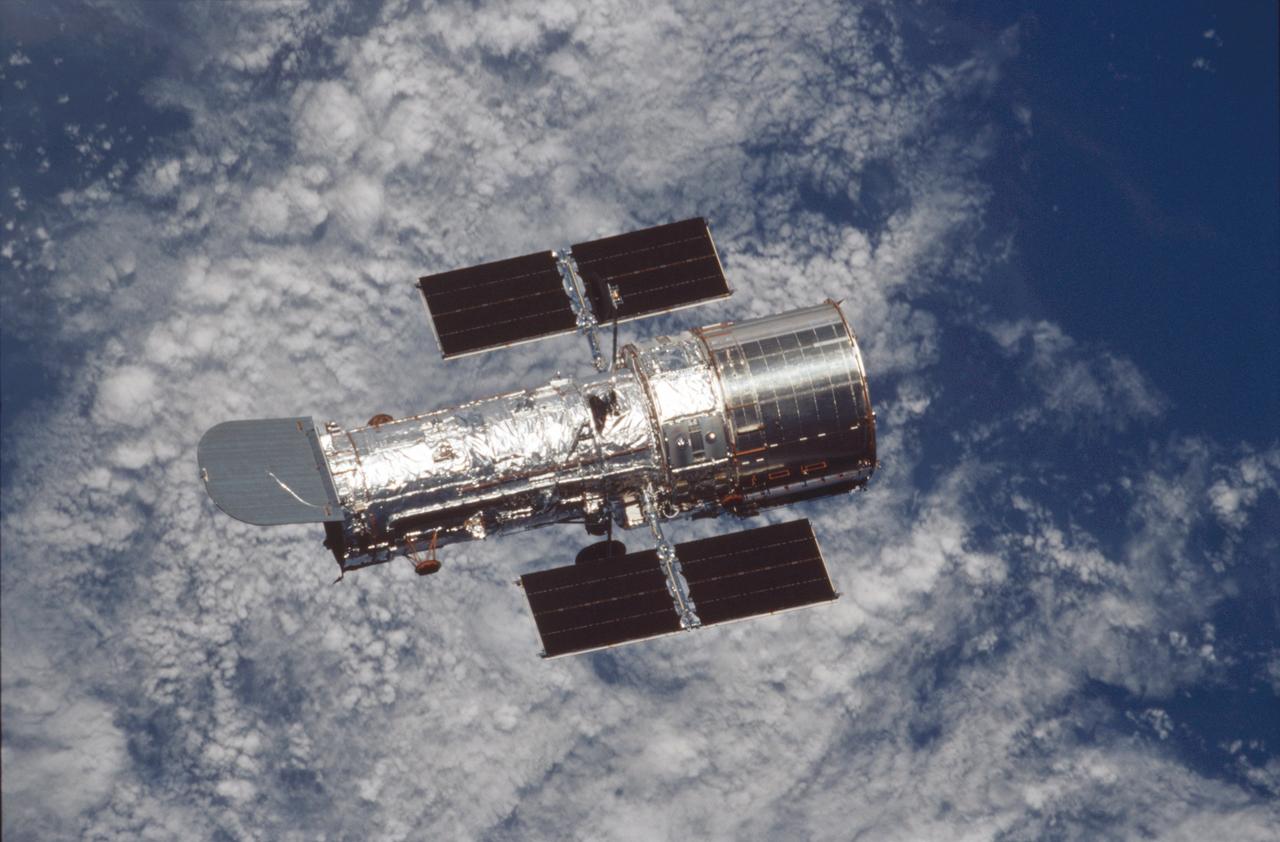 After five days of service and upgrade work on the Hubble Space Telescope (HST), the   STS-109 crew photographed the giant telescope returning to its normal routine. The   telescope was captured and secured on a work stand in Columbia's payload bay using   Columbia's robotic arm, where 4 of the 7-member crew performed 5 space walks   completing system upgrades to the HST. Included in those upgrades were: The   replacement of the solar array panels; replacement of the power control unit (PCU);   replacement of the Faint Object Camera (FOC) with a new advanced camera for Surveys   (ACS); and installation of the experimental cooling system for the Hubble's Near-  Infrared Camera and Multi-object Spectrometer (NICMOS), which had been dormant   since January 1999 when its original coolant ran out. The Marshall Space Flight Center   had the responsibility for the design, development, and construction of the the HST,   which is the most complex and sensitive optical telescope ever made, to study the   cosmos from a low-Earth orbit. Launched March 1, 2002, the STS-109 HST servicing   mission lasted 10 days, 22 hours, and 11 minutes. It was the 108th flight overall in   NASA's Space Shuttle Program.