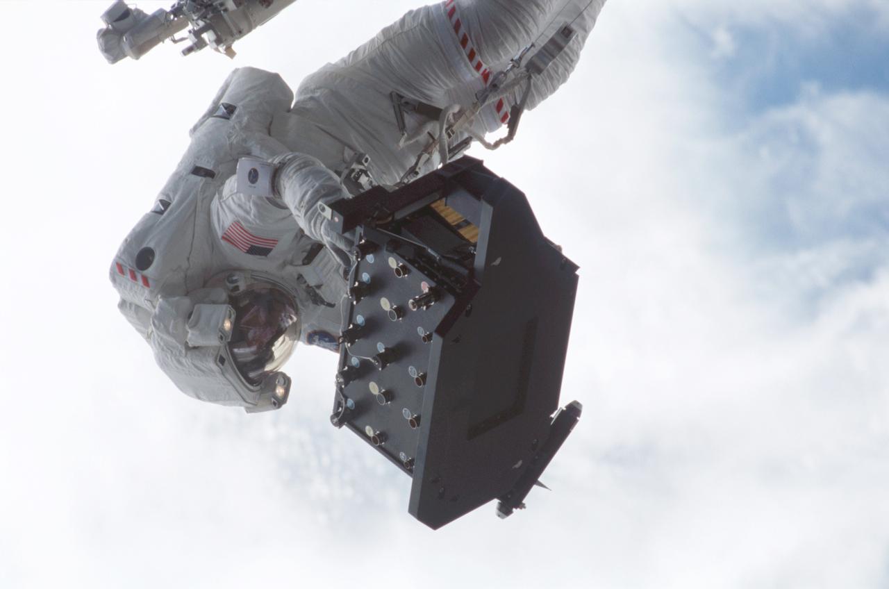 STS-109 Astronaut Michael J. Massimino, mission specialist, perched on the Shuttle's robotic arm, is preparing to install the Electronic Support Module (ESM) in the aft shroud of the Hubble Space telescope (HST), with the assistance of astronaut James H. Newman (out of frame). The module will support a new experimental cooling system to be installed during the next day's fifth and final space walk of the mission. That cooling system is designed to bring the telescope's Near-Infrared Camera and Multi Spectrometer (NICMOS) back to life the which had been dormant since January 1999 when its original coolant ran out. The Space Shuttle Columbia STS-109 mission lifted off March 1, 2002 with goals of repairing and upgrading the Hubble Space Telescope (HST). The Marshall Space Flight Center in Huntsville, Alabama had the responsibility for the design, development, and construction of the HST, which is the most powerful and sophisticated telescope ever built. In addition to the installation of the experimental cooling system for the Hubble's Near-Infrared Camera and NICMOS, STS-109 upgrades to the HST included replacement of the solar array panels, replacement of the power control unit (PCU), and replacement of the Faint Object Camera (FOC) with a new advanced camera for Surveys (ACS). Lasting 10 days, 22 hours, and 11 minutes, the STS-109 mission was the 108th flight overall in NASA's Space Shuttle Program.