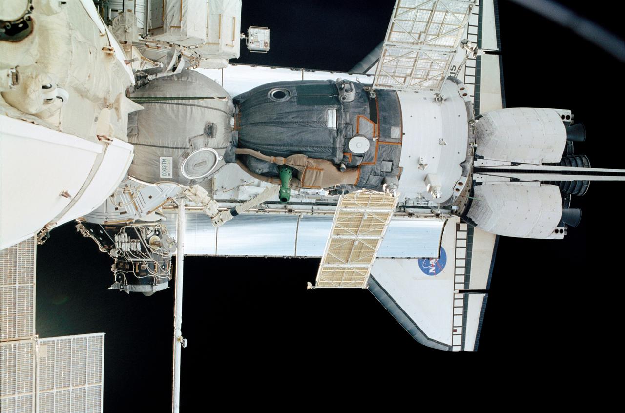 Docked to the International Space Station (ISS), a Soyuz vehicle (foreground) and the Space Shuttle Atlantis were photographed by a crew member in the Pirs docking compartment on the orbital outpost. Atlantis launched on April 8, 2002, carrying the the STS-110 mission which prepared the ISS for future space walks by installing and outfitting the 43-foot-long Starboard side S0 (S-zero) truss and preparing the first railroad in space, the Mobile Transporter. The 27,000 pound S0 truss was the first of 9 segments that will make up the Station's external framework that will eventually stretch 356 feet (109 meters), or approximately the length of a football field. This central truss segment also includes a flatcar called the Mobile Transporter and rails that will become the first "space railroad," which will allow the Station's robotic arm to travel up and down the finished truss for future assembly and maintenance. The completed truss structure will hold solar arrays and radiators to provide power and cooling for additional international research laboratories from Japan and Europe that will be attached to the Station. STS-110 Extravehicular Activity (EVA) marked the first use of the Station's robotic arm to maneuver space walkers around the Station and was the first time all of a shuttle crew's scapulas were based out of the Station's Quest Airlock.