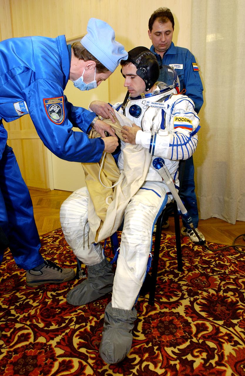 April 10, 2003.  Baikonur Cosmodrome, Kazakhstan. Building 254, Soyuz Integration Facility.  Cosmonaut Yuri I. Malenchenko, Expedition Seven commander dons his Russian Sokol suit for the leak check and Soyuz inspection, seat liner check. Photo Credit: "NASA/Bill Ingalls"