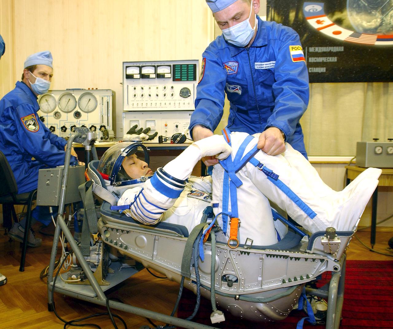 April 10, 2003.  Baikonur Cosmodrome, Kazakhstan. Building 254, Soyuz Integration Facility.  Astronaut Edward T. Lu, NASA ISS science officer and flight engineer for Expedition Seven has a leak check preformed on the Russian Sokol suit.  Photo Credit: "NASA/Bill Ingalls"