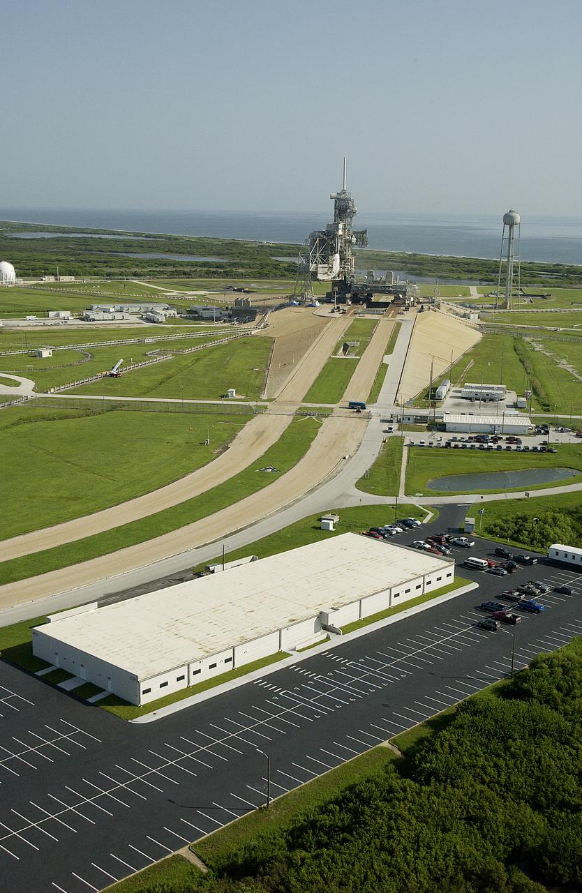 KENNEDY SPACE CENTER, FLA. –  In this aerial view, the crawlerway (center) leads to Launch Pad 39A.  At right is one of the new Launch Pad facilities buildings that provides both office and shop space.                                 