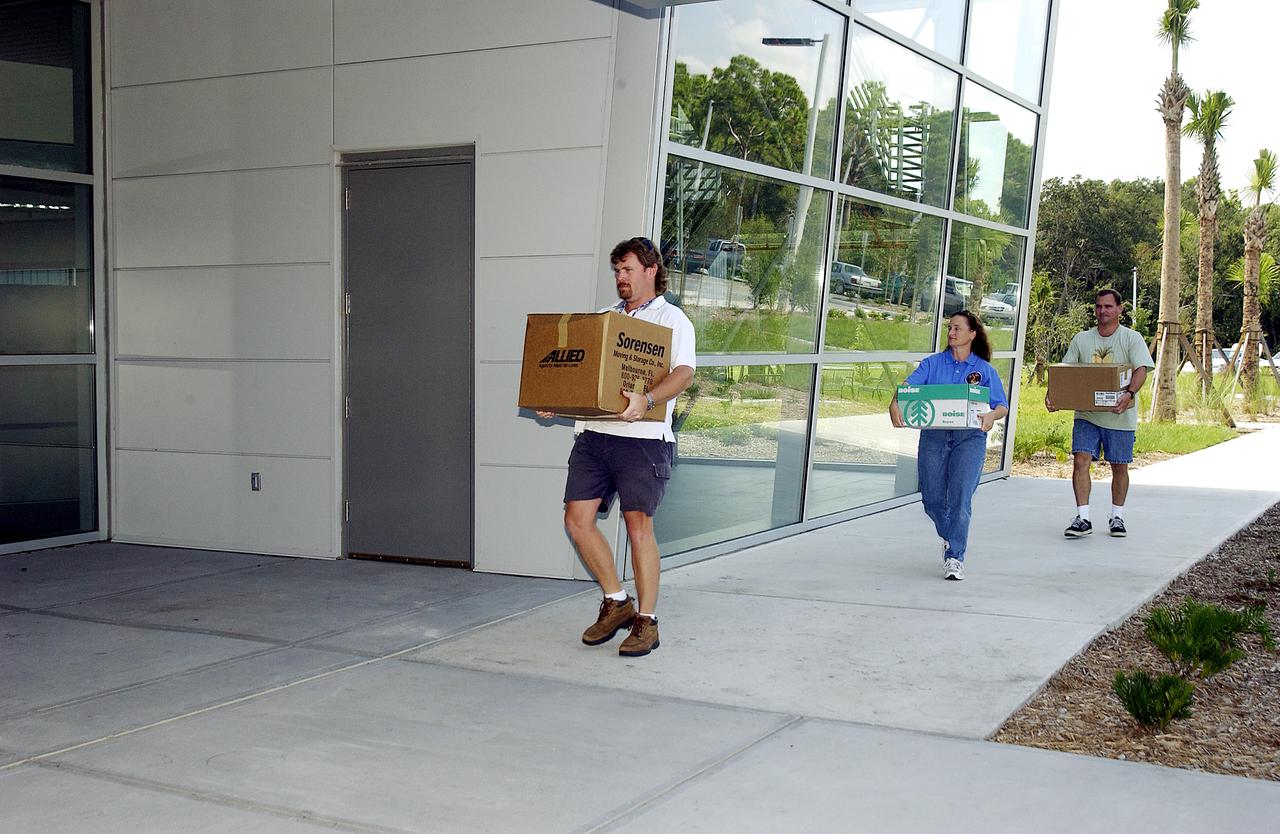 KENNEDY SPACE CENTER, FLA. -  Dynamac employees (from left) Larry Burns, Debbie Wells and Neil  Yorio carry boxes of hardware into the Space Life Sciences Lab (SLSL), formerly known as the Space Experiment Research and Processing Laboratory (SERPL).   They are transferring equipment from Hangar L. The new lab is a state-of-the-art facility being built for ISS biotechnology research. Developed as a partnership between NASA-KSC and the State of Florida, NASA’s life sciences contractor will be the primary tenant of the facility, leasing space to conduct flight experiment processing and NASA-sponsored research. About 20 percent of the facility will be available for use by Florida’s university researchers through the Florida Space Research Institute.