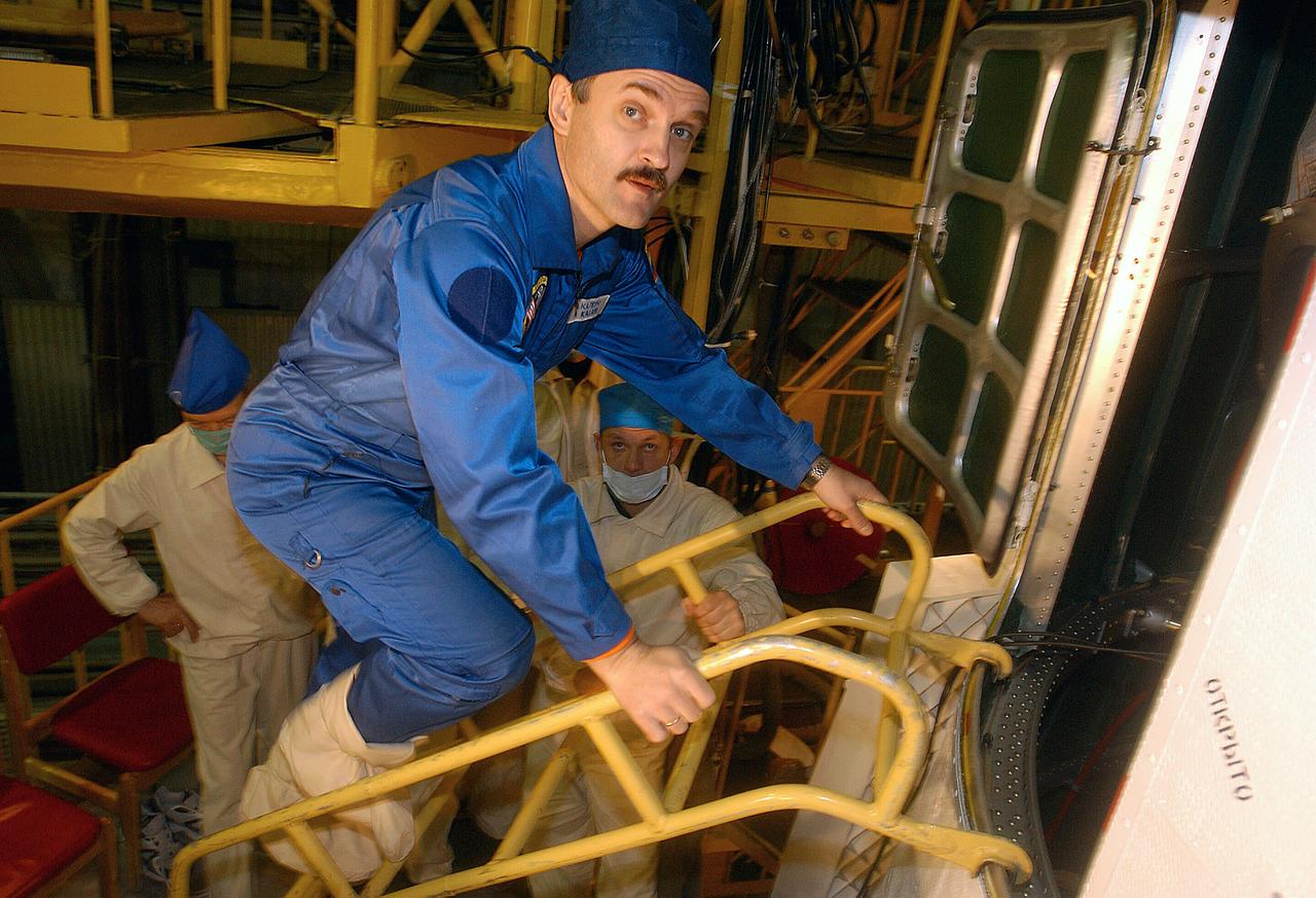 October 13, 2003.  Baikonur Cosmodrome, Kazakhstan. Expedition 8 Soyuz Commander Alexander Kaleri climbs into the Soyuz TMA-3 vehicle in a processing facility at the Baikonur Cosmodrome in Kazakhstan on Oct. 13, 2003 during prelaunch training with his crew mates, Expedition 8 Commander and NASA Science Officer Mike Foale and European Space Agency Astronaut Pedro Duque of Spain. The trio will be launched on Oct. 18 to the International Space Station.  Photo Credit"NASA/Bill Ingalls"