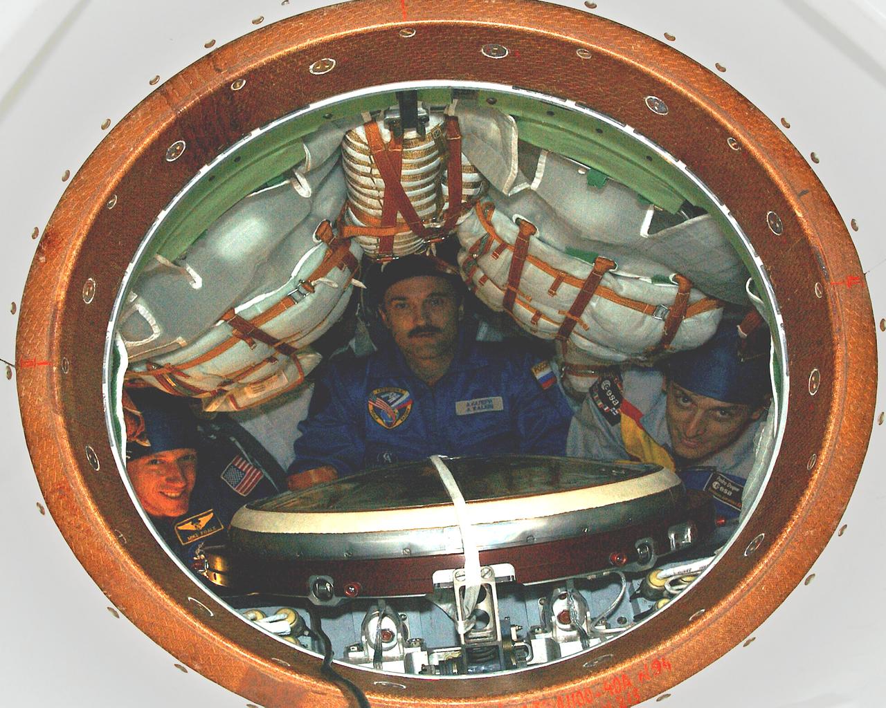 October 13, 2003.  Baikonur Cosmodrome, Kazakhstan. Expedition 8 Commander and NASA Science Officer Mike Foale (left), Expedition 8 Soyuz Commander Alexander Kaleri (center) and European Space Agency Astronaut Pedro Duque of Spain (right) pose inside the Soyuz TMA-3 vehicle in a processing facility at the Baikonur Cosmodrome in Kazakhstan Oct. 13, 2003 during a prelaunch inspection. The trio will be launched to the International Space Station on Oct. 18.  Photo Credit"NASA/Bill Ingalls"