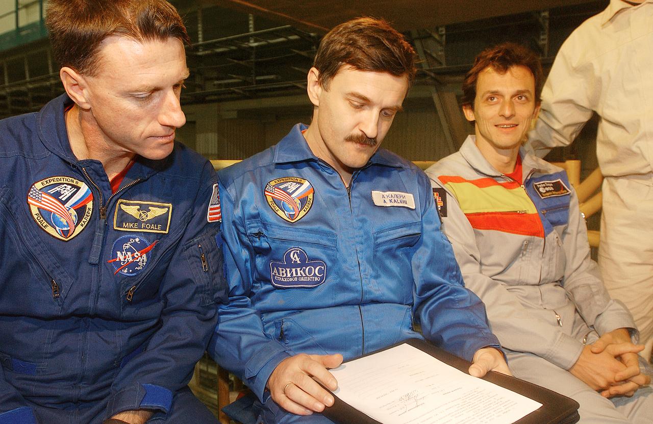 October 13, 2003.  Baikonur Cosmodrome, Kazakhstan. Expedition 8 Commander and NASA Science Officer Mike Foale (left), Expedition 8 Soyuz Commander Alexander Kaleri (center) and European Space Agency Astronaut Pedro Duque of Spain (right) receive a briefing in a processing facility at the Baikonur Cosmodrome in Kazakhstan Oct. 13, 2003 during a prelaunch inspection of their Soyuz TMA-3 spacecraft. The trio will be launched to the International Space Station on Oct. 18.  Photo Credit"NASA/Bill Ingalls"