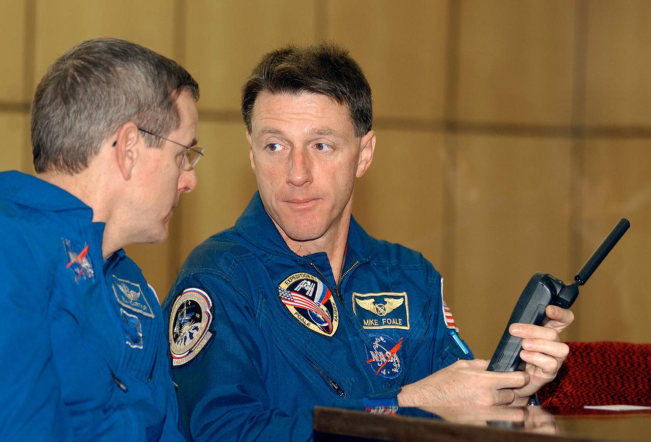October 15, 2003. Cosmonaut Hotel, Baikonur, Kazakhstan. Backup Expedition 8 Commander Bill McArthur (left) and prime Expedition 8 Commander Mike Foale practice procedures with a satellite phone during final training at their crew quarters in Baikonur, Kazakhstan Oct. 15, 2003 for launch on a Soyuz TMA-3 vehicle Oct. 18 to the International Space Station. Foale will be joined for launch by Expedition 8 Soyuz Commander Alexander Kaleri and European Space Agency Pedro Duque of Spain. Photo Credit: "NASA/Bill Ingalls"