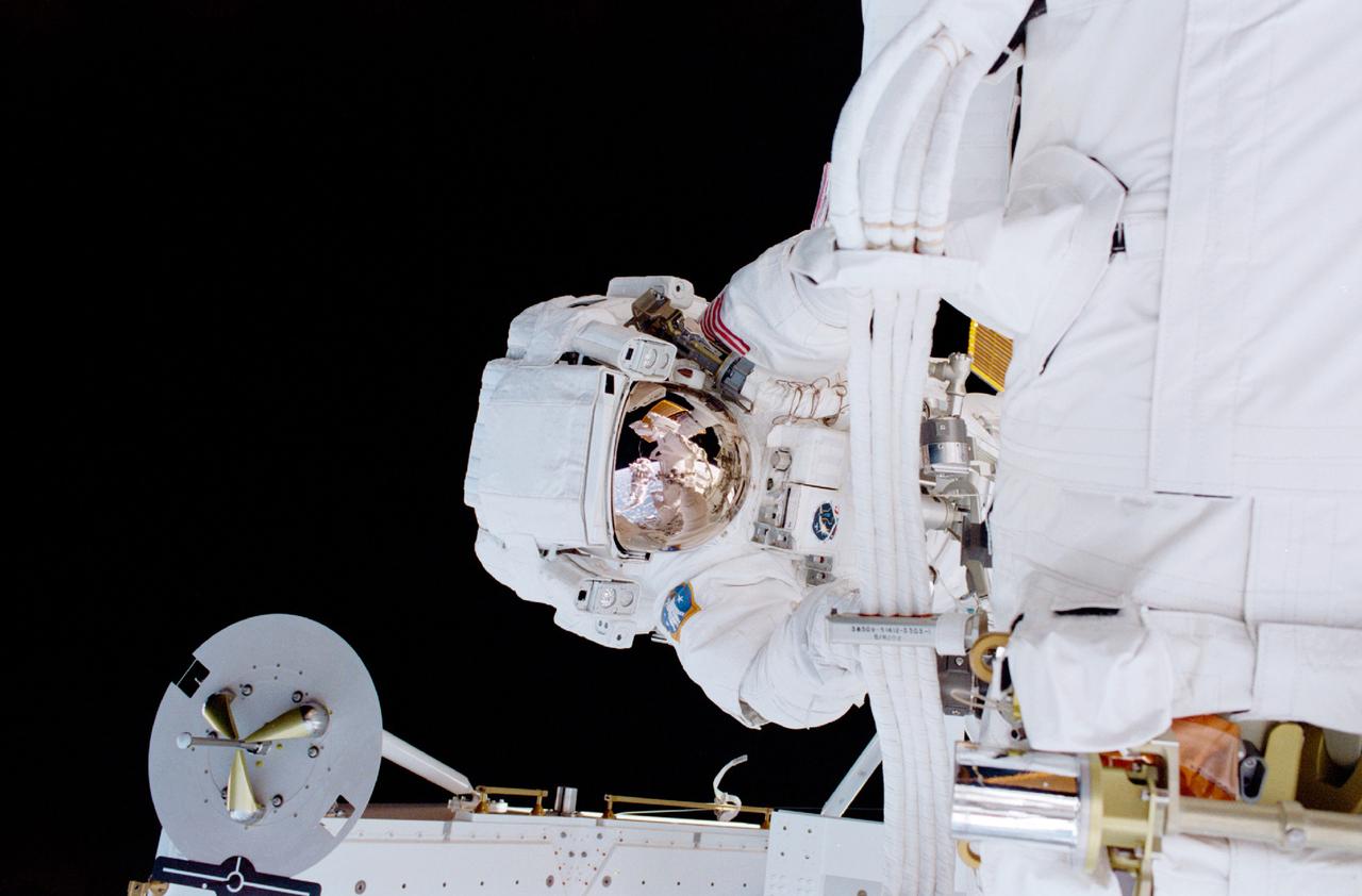 The main objective of the STS-100 mission, the sixth International Space Station (ISS) assembly flight, was the delivery and installation of the Canadian-built Space Station Remote Manipulator System (SSRMS), or Canadarm2. In this photograph, astronaut Scott E. Parazynski, mission specialist, works with cables associated with the robotic arm during one of two days of extravehicular activity (EVA). Both space walks were shared with Chris A. Hadfield, mission specialist representing the Canadian Space Agency (CSA), who is visible in the helmet visor of Parazynski. STS-100 launched April 19, 2001 aboard the Space Shuttle Orbiter Endeavour for an 11 day mission.