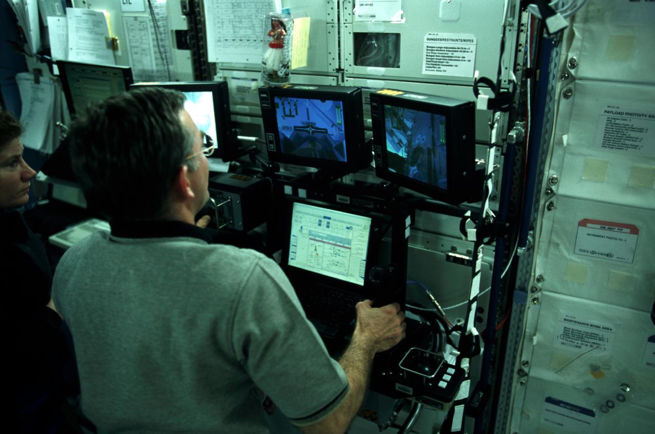 A Canadian "handshake" in space occurred on April 28, 2001, as the Canadian-built space station robotic arm (Canadarm2) transferred its launch cradle over to Endeavour's robotic arm. Pictured is astronaut James S. Voss, Expedition Two flight engineer, working the controls of the new robotic arm. Marning the controls from the shuttle's aft flight deck, Canadian Mission Specialist Chris A. Hadfield of the Canadian Space Agency (CSA) was instrumental in the activity. The Space lab pallet that carried the Canadarm2 robotic arm to the station was developed at the Marshall Space Flight Center (MSFC) in Huntsville, Alabama.