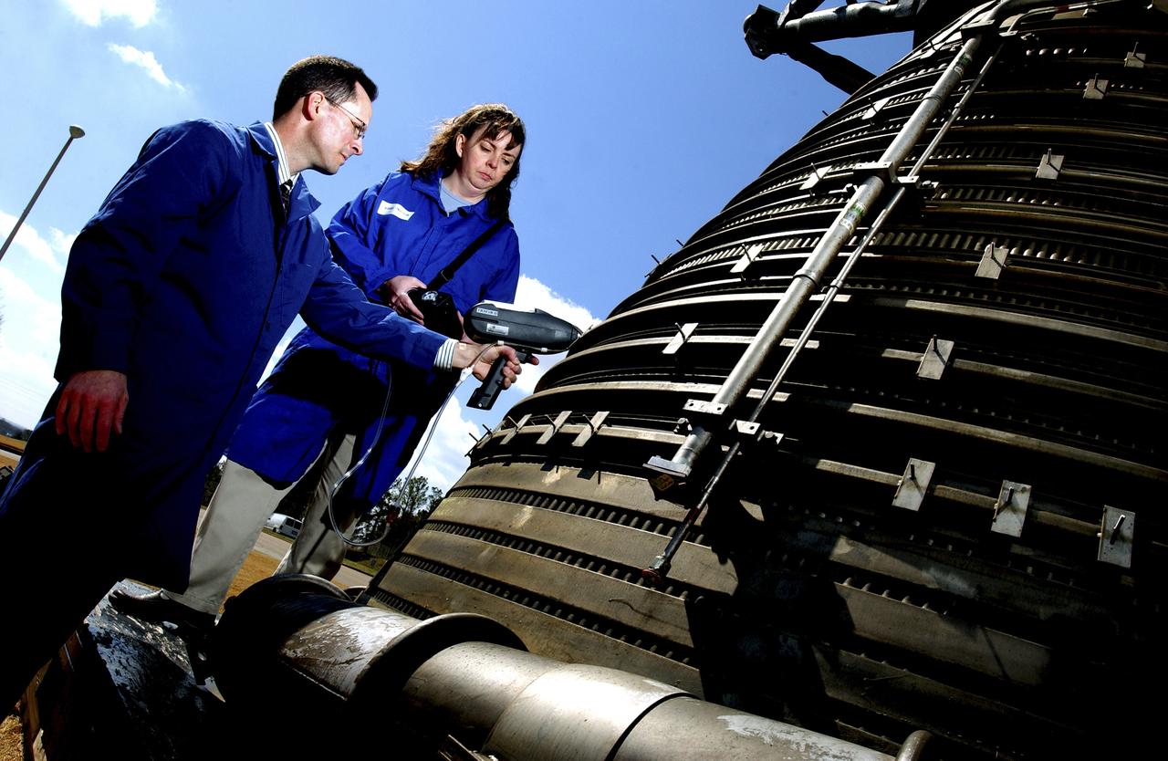 Teamed with KeyMaster Technologies, Kennewick, Washington, the Marshall Space Flight Center engineers have developed a portable vacuum analyzer that performs on-the-spot chemical analyses under field conditions— a task previously only possible in a chemical laboratory. The new capability is important not only to the aerospace industry, but holds potential for broad applications in any industry that depends on materials analysis, such as the automotive and pharmaceutical industries. Weighing in at a mere 4 pounds, the newly developed handheld vacuum X-ray fluorescent analyzer can identify and characterize a wide range of elements, and is capable of detecting chemical elements with low atomic numbers, such as sodium, aluminum and silicon. It is the only handheld product on the market with that capability. Aluminum alloy verification is of particular interest to NASA because vast amounts of high-strength aluminum alloys are used in the Space Shuttle propulsion system such as the External Tank, Main Engine, and Solid Rocket Boosters. This capability promises to be a boom to the aerospace community because of unique requirements, for instance, the need to analyze Space Shuttle propulsion systems on the launch pad. Those systems provide the awe-inspiring rocket power that propels the Space Shuttle from Earth into orbit in mere minutes. The scanner development also marks a major improvement in the quality assurance field, because screws, nuts, bolts, fasteners, and other items can now be evaluated upon receipt and rejected if found to be substandard. The same holds true for aluminum weld rods.  The ability to validate the integrity of raw materials and partially finished products before adding value to them in the manufacturing process will be of benefit not only to businesses, but also to the consumer, who will have access to a higher value product at a cheaper price. Three vacuum X-ray scanners are already being used in the Space Shuttle Program. The External Tank Project Office is using one for aluminum alloy analysis, while a Marshall contractor is evaluating alloys with another unit purchased for the Space Shuttle Main Engine Office. The Reusable Solid Rocket Motor Project Office has obtained a scanner that is being used to test hardware and analyze materials. In this photograph, Richard Booth, Marshall Engineering Directorate, and Wanda Hudson, ATK Thiokol, use an enhanced vacuum X-ray fluorescent scanner to analyze materials  in an F-1 engine, which was used to boost the Saturn V rocket from Earth’s orbit that carried astronauts to the moon in the 1960s.