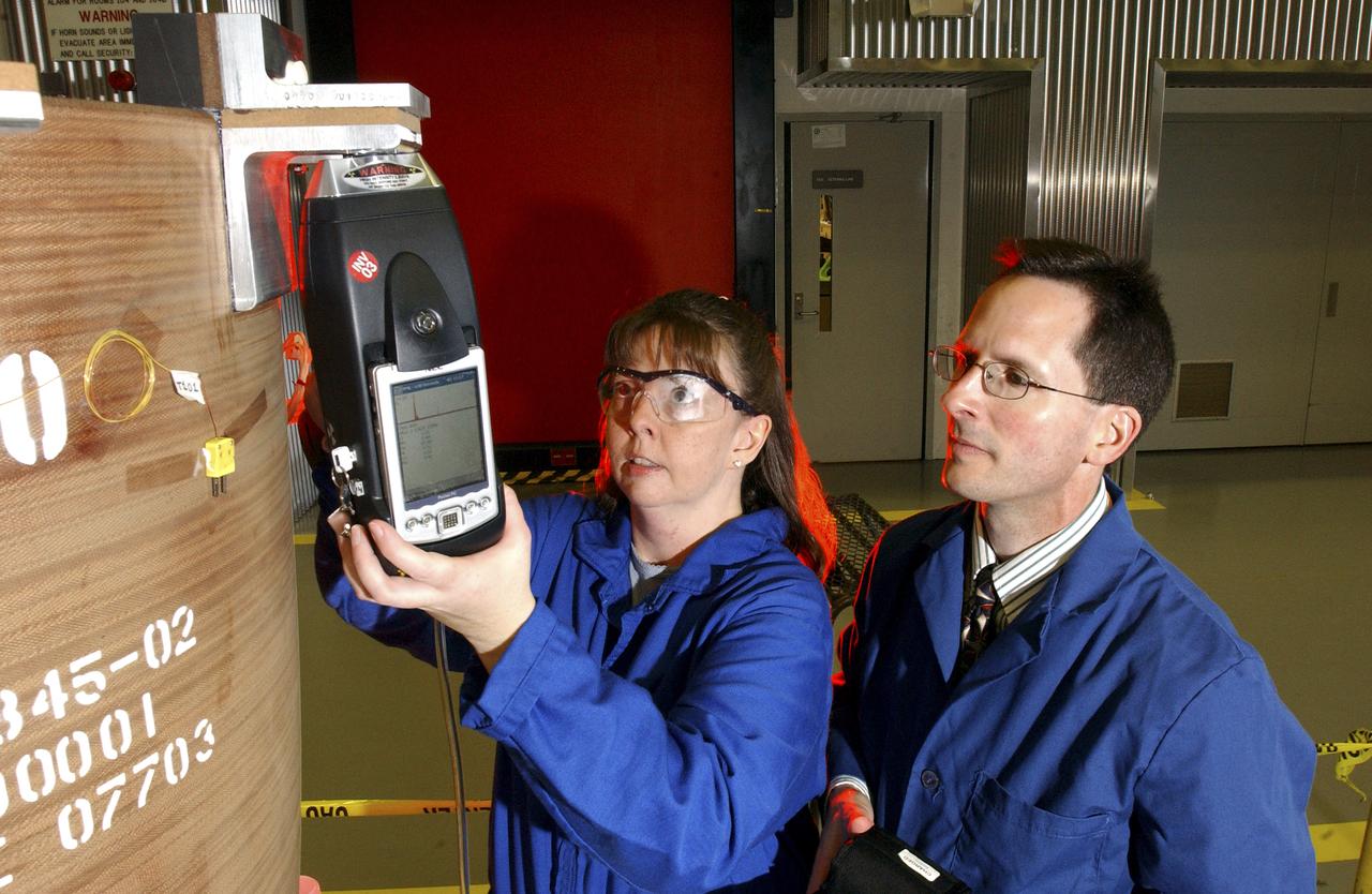 Teamed with KeyMaster Technologies, Kennewick, Washington, the Marshall Space Flight Center engineers have developed a portable vacuum analyzer that performs on-the-spot chemical analyses under field conditions— a task previously only possible in a chemical laboratory. The new capability is important not only to the aerospace industry, but holds potential for broad applications in any industry that depends on materials analysis, such as the automotive and pharmaceutical industries. Weighing in at a mere 4 pounds, the newly developed handheld vacuum X-ray fluorescent analyzer can identify and characterize a wide range of elements, and is capable of detecting chemical elements with low atomic numbers, such as sodium, aluminum and silicon. It is the only handheld product on the market with that capability. Aluminum alloy verification is of particular interest to NASA because vast amounts of high-strength aluminum alloys are used in the Space Shuttle propulsion system such as the External Tank, Main Engine, and Solid Rocket Boosters. This capability promises to be a boom to the aerospace community because of unique requirements, for instance, the need to analyze Space Shuttle propulsion systems on the launch pad. Those systems provide the awe-inspiring rocket power that propels the Space Shuttle from Earth into orbit in mere minutes. The scanner development also marks a major improvement in the quality assurance field, because screws, nuts, bolts, fasteners, and other items can now be evaluated upon receipt and rejected if found to be substandard. The same holds true for aluminum weld rods.  The ability to validate the integrity of raw materials and partially finished products before adding value to them in the manufacturing process will be of benefit not only to businesses, but also to the consumer, who will have access to a higher value product at a cheaper price. Three vacuum X-ray scanners are already being used in the Space Shuttle Program. The External Tank Project Office is using one for aluminum alloy analysis, while a Marshall contractor is evaluating alloys with another unit purchased for the Space Shuttle Main Engine Office. The Reusable Solid Rocket Motor Project Office has obtained a scanner that is being used to test hardware and analyze materials. In this photograph, Wanda Hudson, left, ATK Thiokol, and Richard Booth, Marshall Engineering Directorate, use an enhanced vacuum X-ray fluorescent scanner to evaluate Reusable Solid Rocket Motor hardware.