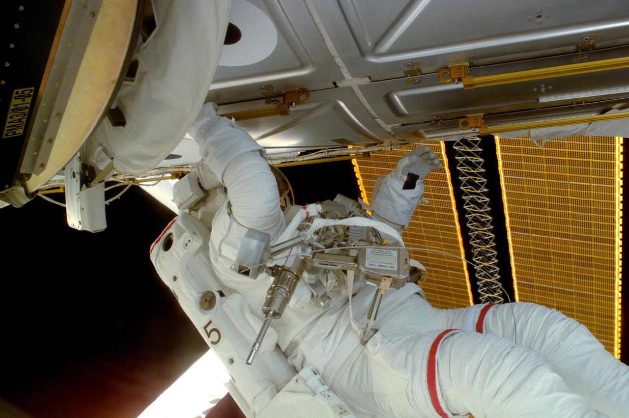 Astronaut Joseph R. Tanner, STS-97 mission specialist, is seen during a session of Extravehicular Activity (EVA), performing work on the International Space Station (ISS). Part of the Remote Manipulator System (RMS) arm and a section of the newly deployed solar array panel are in the background. The primary objective of the STS-97 mission was the delivery, assembly, and activation of the U.S. electrical power system on board the ISS. The electrical power system, which is built into a 73-meter (240-foot) long solar array structure consists of solar arrays, radiators, batteries, and electronics. The entire 15.4-metric ton (17-ton) package is called the P6 Integrated Truss Segment and is the heaviest and largest element yet delivered to the station aboard a space shuttle. The electrical system will eventually provide the power necessary for the first ISS crews to live and work in the U.S. segment. The STS-97 crew of five launched aboard the Space Shuttle Orbiter Endeavor on November 30, 2000 for an 11 day mission.