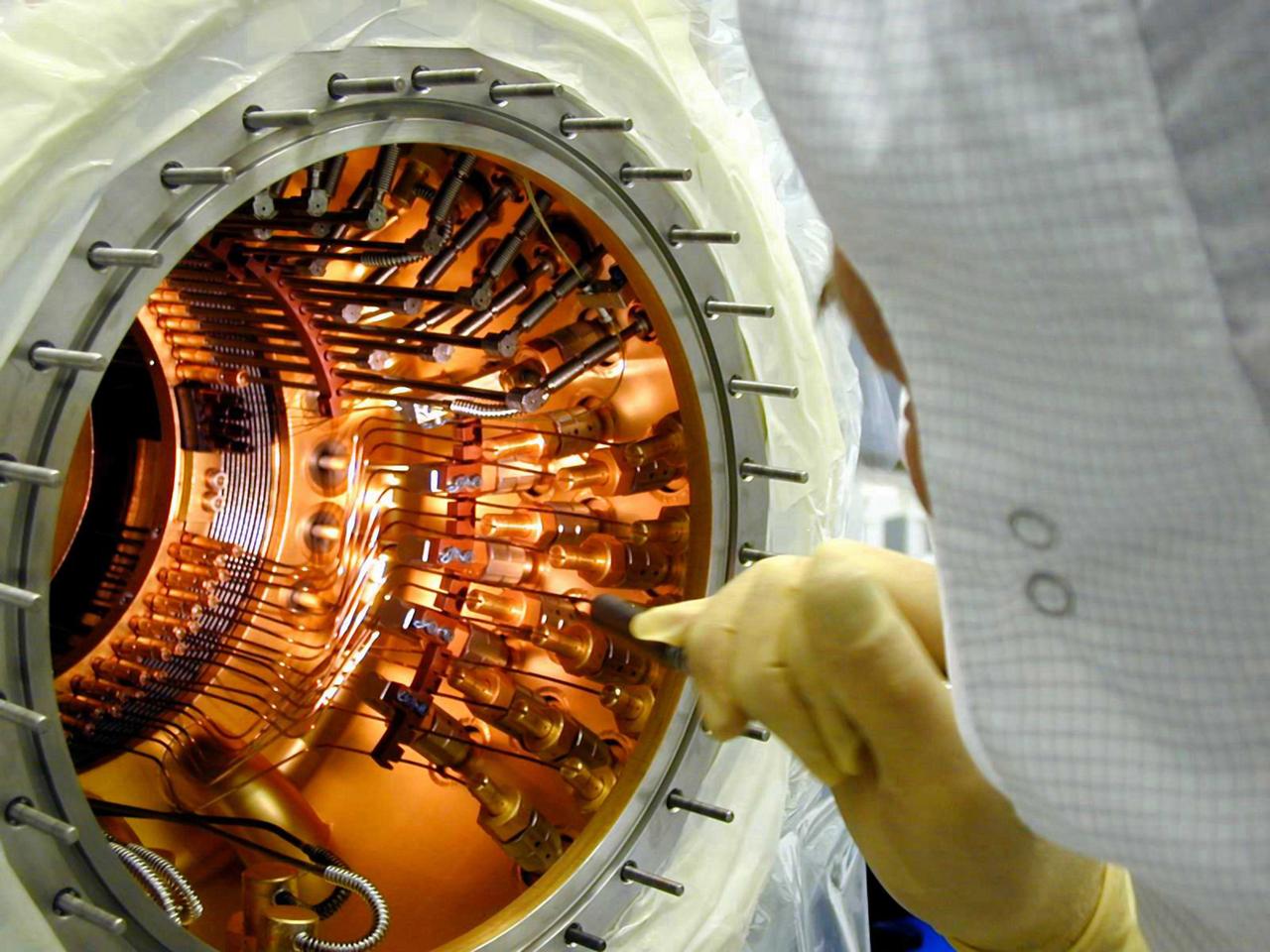 The space vehicle Gravity Probe B (GP-B) is the relativity experiment developed at Stanford University to test two extraordinary predictions of Albert Einstein’s general theory of relativity. The experiment will measure, very precisely, the expected tiny changes in the direction of the spin axes of four gyroscopes contained in an Earth-orbiting satellite at a 400-mile altitude. So free are the gyroscopes from disturbance that they will provide an almost perfect space-time reference system. They will measure how space and time are very slightly warped by the presence of the Earth, and, more profoundly, how the Earth’s rotation very slightly drags space-time around with it. These effects, though small for the Earth, have far-reaching implications for the nature of matter and the structure of the Universe. GP-B is among the most thoroughly researched programs ever undertaken by NASA. This is the story of a scientific quest in which physicists and engineers have collaborated closely over many years. Inspired by their quest, they have invented a whole range of technologies that are already enlivening other branches of science and engineering. In this photograph, engineer Gary Reynolds is inspecting the inside of the probe neck during probe thermal repairs. GP-B is scheduled for launch in April 2004 and managed for NASA by the Marshall Space Flight Center. Development of the GP-B is the responsibility of Stanford University along with major subcontractor Lockheed Martin Corporation.  (Image credit to Russ Leese, Gravity Probe B, Stanford University)