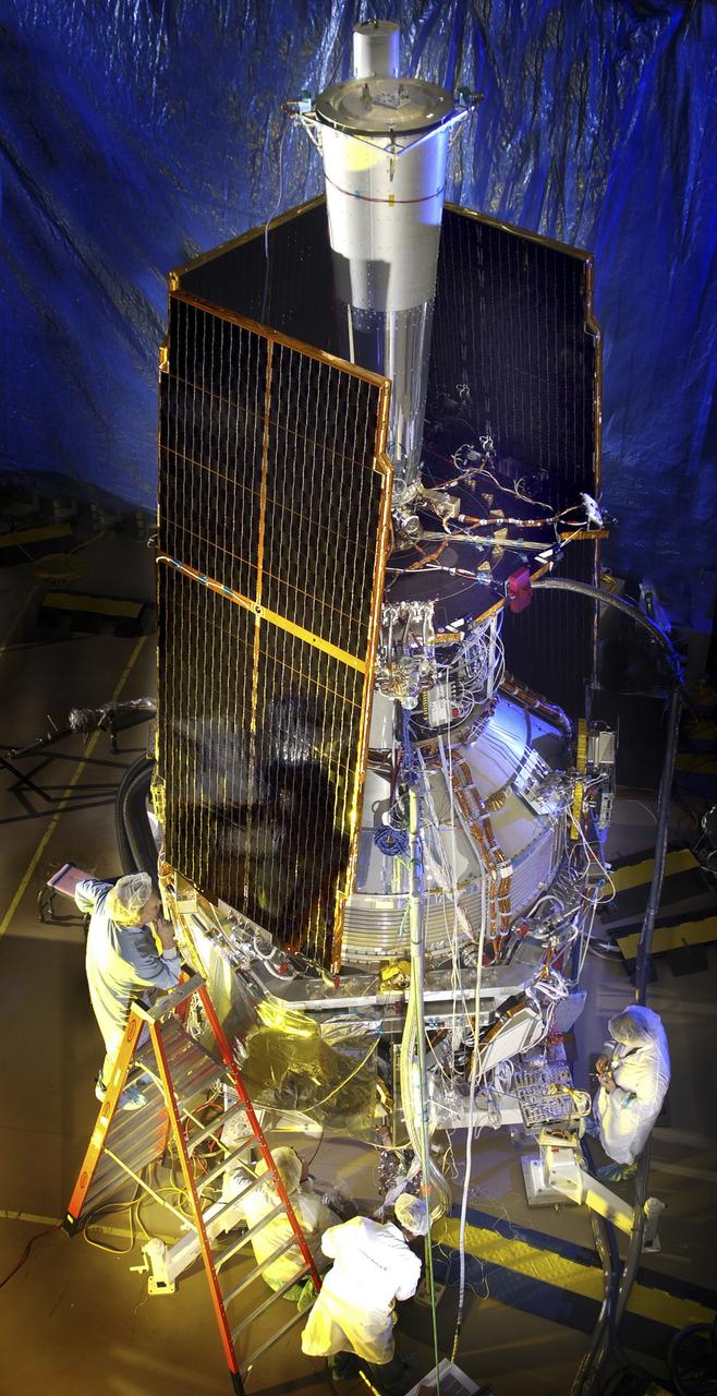 In this photo, the Gravity Probe B (GP-B) space vehicle is completed during the solar array installation. The GP-B is the relativity experiment developed at Stanford University to test two extraordinary predictions of Albert Einstein’s general theory of relativity. The experiment will measure, very precisely, the expected tiny changes in the direction of the spin axes of four gyroscopes contained in an Earth-orbiting satellite at a 400-mile altitude. So free are the gyroscopes from disturbance that they will provide an almost perfect space-time reference system. They will measure how space and time are very slightly warped by the presence of the Earth, and, more profoundly, how the Earth’s rotation very slightly drags space-time around with it. These effects, though small for the Earth, have far-reaching implications for the nature of matter and the structure of the Universe. GP-B is among the most thoroughly researched programs ever undertaken by NASA. This is the story of a scientific quest in which physicists and engineers have collaborated closely over many years. Inspired by their quest, they have invented a whole range of technologies that are already enlivening other branches of science and engineering.  GP-B is scheduled for launch in April 2004 and managed for NASA by the Marshall Space Flight Center. Development of the GP-B is the responsibility of Stanford University along with major subcontractor Lockheed Martin Corporation.  (Image credit to Russ Underwood, Lockheed Martin Corporation).