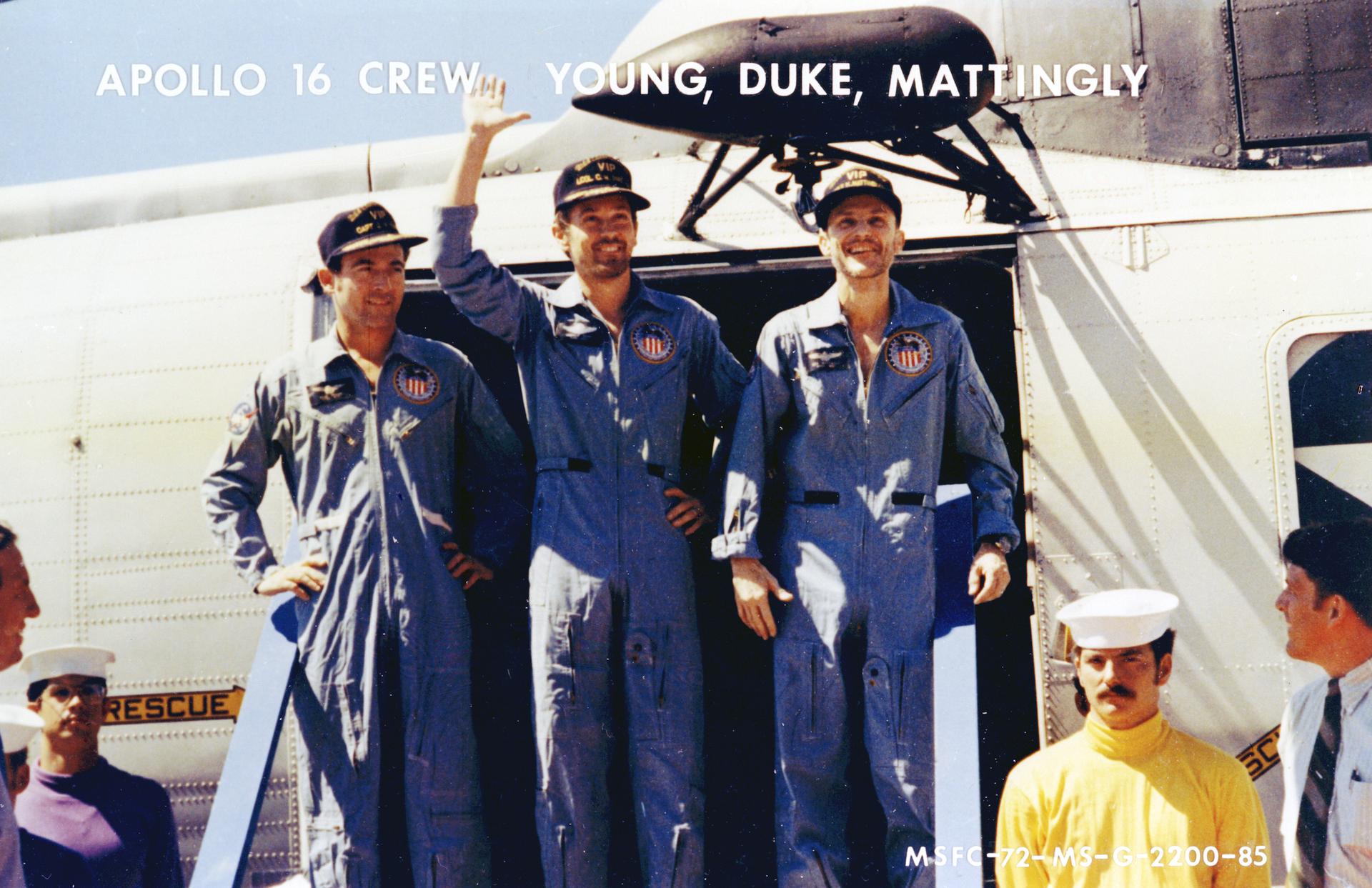 The Apollo 16 crew waves after disembarking from the recovery helicopter after splashdown