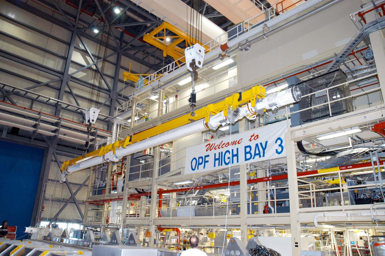 KENNEDY SPACE CENTER, FLA. - The Remote Manipulator System (RMS), also known as the Canadian robotic arm, is moved in the Orbiter Processing Facility for installation in Discovery’s payload bay.  The RMS is used to deploy and retrieve payloads, provide a mobile extension ladder or foot restraints for crew members during extravehicular activities; and to aid the flight crew members in viewing surfaces of the orbiter or payloads through a television camera on the RMS. The arm is also serving as the base for the new Orbiter Boom Sensor System (OBSS), one of the safety measures for Return to Flight, equipping the Shuttle with cameras and laser systems to inspect the Shuttle’s Thermal Protection System while in space.  Discovery is scheduled for a launch planning window of May 2005 on Return to Flight mission STS-114.