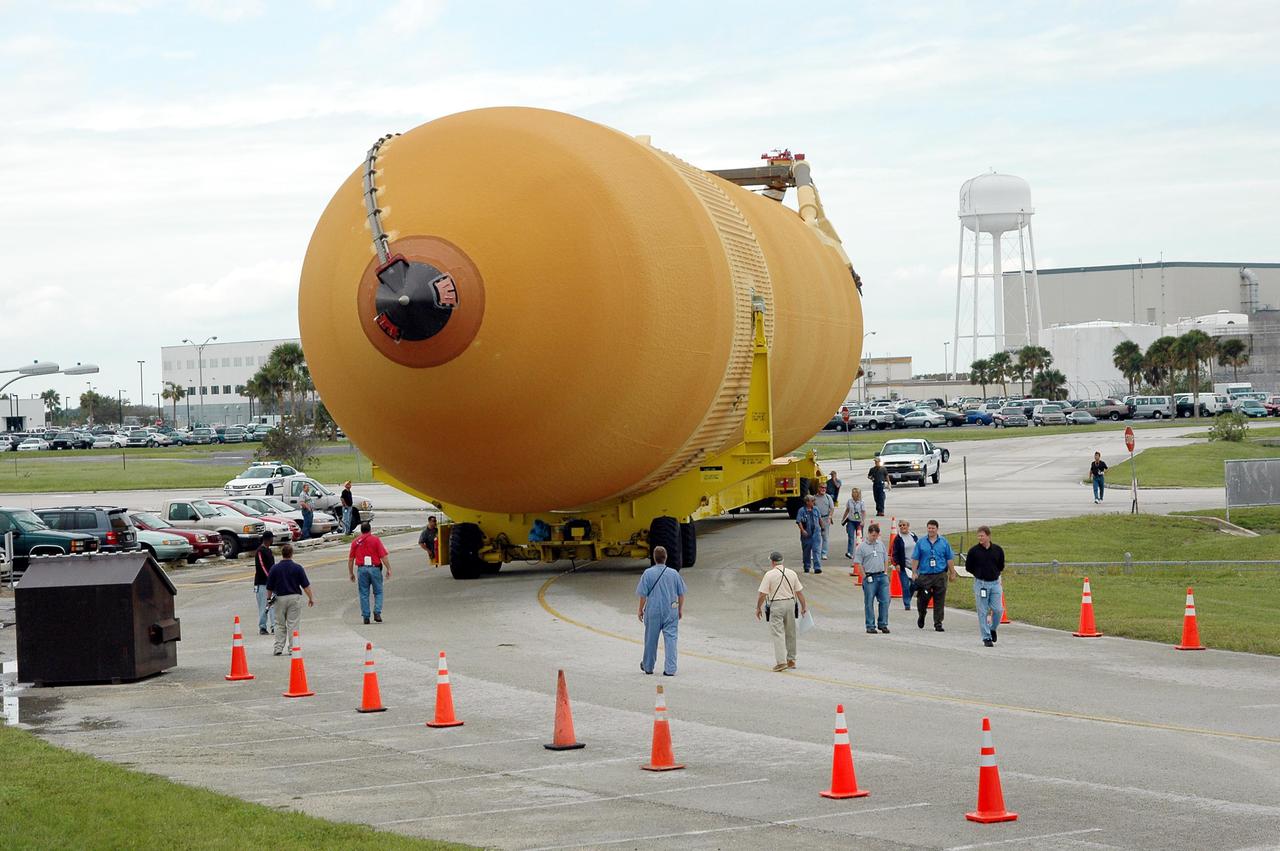 KENNEDY SPACE CENTER, FLA. -   External Tank 118 (ET-118) is transferred from the Vehicle Assembly Building to the barge in the Turn Basin at Launch Complex 39. The tank will be transported to NASA’s Michoud Assembly Facility in New Orleans.  The tank is being installed with an improved bipod fitting, which connects the external fuel tank to the Shuttle during launch. The new design, a significant milestone in the effort to return the Shuttle to safe flight, replaces the foam that was used to prevent ice buildup on the tank’s bipod fittings with four rod-shaped heaters.  The heaters are being retrofitted on the 11 existing tanks and incorporated into the manufacture of all new tanks.