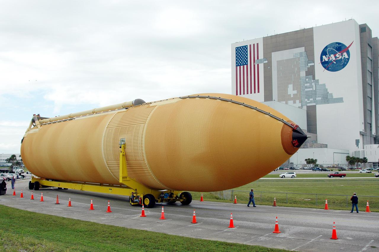 KENNEDY SPACE CENTER, FLA. -   External Tank 118 (ET-118) moves from the Vehicle Assembly Building, in the background, toward the barge in the Turn Basin at Launch Complex 39. The tank will be transported to NASA’s Michoud Assembly Facility in New Orleans.  The tank is being installed with an improved bipod fitting, which connects the external fuel tank to the Shuttle during launch. The new design, a significant milestone in the effort to return the Shuttle to safe flight, replaces the foam that was used to prevent ice buildup on the tank’s bipod fittings with four rod-shaped heaters.  The heaters are being retrofitted on the 11 existing tanks and incorporated into the manufacture of all new tanks.