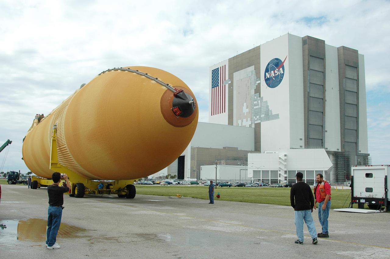 KENNEDY SPACE CENTER, FLA. -   External Tank 118 (ET-118) progresses slowly from the Vehicle Assembly Building, in the background, to the barge in the Turn Basin at Launch Complex 39. The tank will be transported to NASA’s Michoud Assembly Facility in New Orleans.  The tank is being installed with an improved bipod fitting, which connects the external fuel tank to the Shuttle during launch. The new design, a significant milestone in the effort to return the Shuttle to safe flight, replaces the foam that was used to prevent ice buildup on the tank’s bipod fittings with four rod-shaped heaters.  The heaters are being retrofitted on the 11 existing tanks and incorporated into the manufacture of all new tanks.