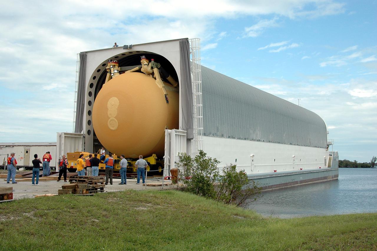 KENNEDY SPACE CENTER, FLA. - At the Turn Basin in Launch Complex 39, KSC workers prepare to secure External Tank 118 (ET-118) in the barge that will transport it to NASA’s Michoud Assembly Facility in New Orleans. It had been stored in the Vehicle Assembly Building. The tank is being installed with an improved bipod fitting, which connects the external fuel tank to the Shuttle during launch. The new design, a significant milestone in the effort to return the Shuttle to safe flight, replaces the foam that was used to prevent ice buildup on the tank’s bipod fittings with four rod-shaped heaters. The heaters are being retrofitted on the 11 existing tanks and incorporated into the manufacture of all new tanks.