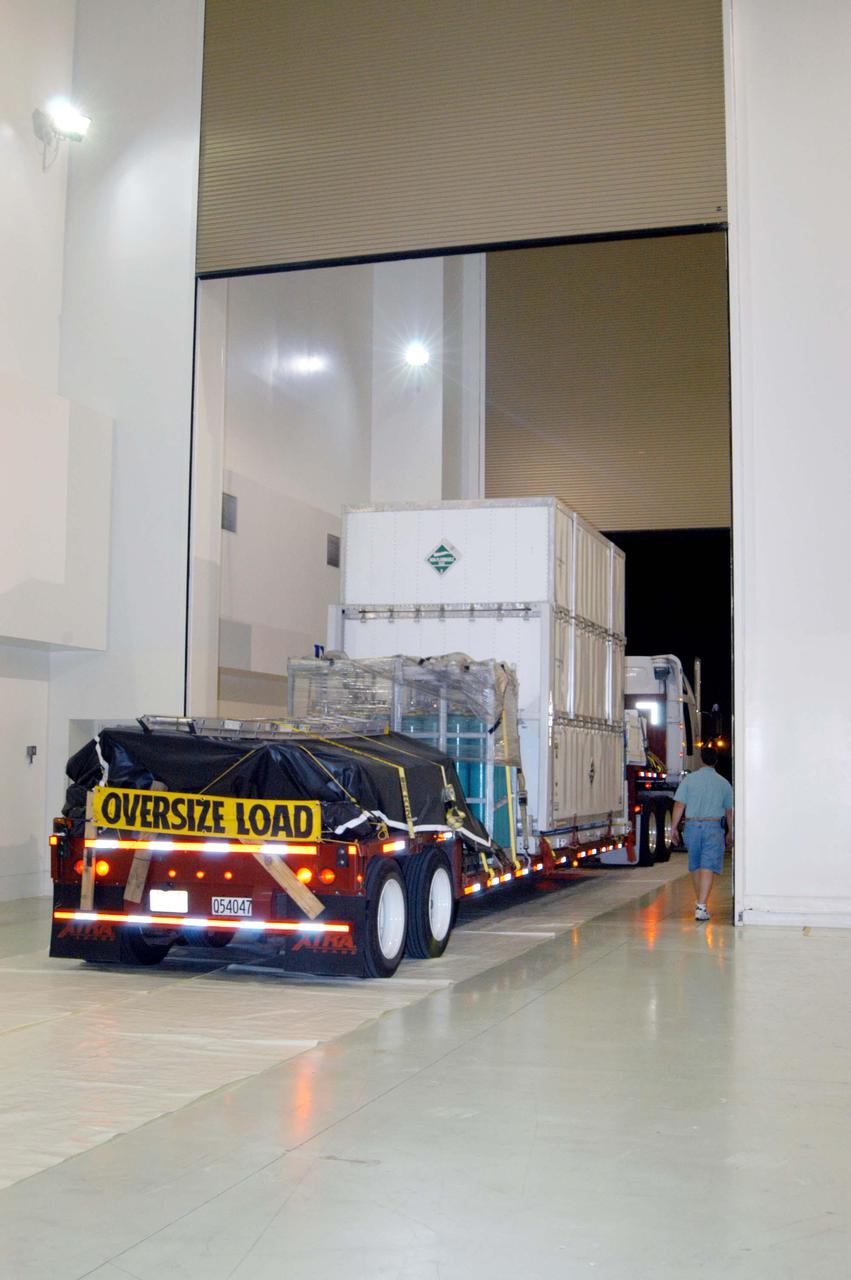 KENNEDY SPACE CENTER, FLA. - The truck carrying the NASA Discovery Mission Deep Impact spacecraft backs into the facility at Astrotech Space Operations near Kennedy Space Center. The spacecraft was transported from Ball Aerospace and Technologies Corp. in Boulder, Colo. Deep Impact is designed to launch a copper projectile into the surface of Comet Tempel 1 on July 4, 2005, when the comet is 83 million miles from Earth. When this 820-pound “impactor” hits the surface of the comet at nearly 23,000 miles per hour, the 3- by 3-foot projectile will create a crater hundreds of feet in size. Deep Impact’s flyby spacecraft will collect pictures and data of how the crater forms, measuring the crater’s depth and diameter, as well as the composition of the interior of the crater and any material thrown out, and determining the changes in natural outgassing produced by the impact. It will send the data back to Earth through the antennas of the Deep Space Network. The spacecraft is scheduled to launch Dec. 30, 2004, aboard a Boeing Delta II rocket from Launch Complex 17 at Cape Canaveral Air Force Station, Fla.