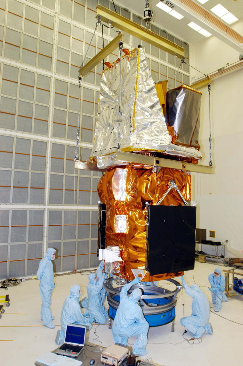 KENNEDY SPACE CENTER, FLA. - Technicians at NASA’s Hangar AE, Cape Canaveral Air Force Station (CCAFS), help guide the Swift spacecraft being lowered onto a payload attach fitting, the interface between the spacecraft and the second stage of the Boeing Delta II rocket. Swift is a first-of-its-kind multi-wavelength observatory dedicated to the study of gamma-ray burst (GRB) science. Its three instruments will work together to observe GRBs and afterglows in the gamma ray, X-ray, ultraviolet and optical wavebands. Swift is expected to observe more than 200 gamma-ray bursts - the most comprehensive study of GRB afterglows to date - during its 2-year mission. Swift is scheduled to launch in November from Launch Pad 17-A at CCAFS.