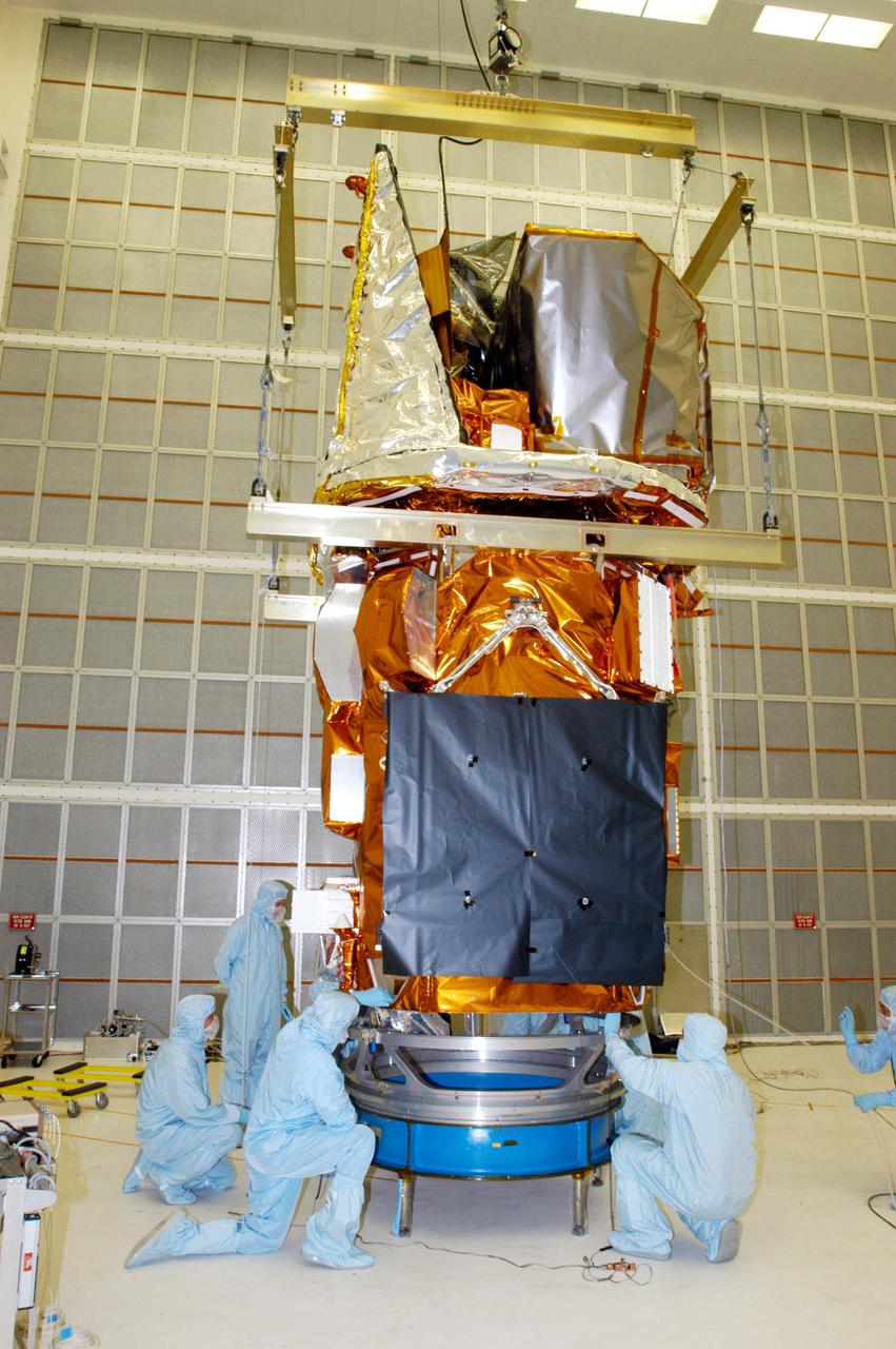 KENNEDY SPACE CENTER, FLA. - Technicians at NASA’s Hangar AE, Cape Canaveral Air Force Station (CCAFS), help guide the Swift spacecraft being lowered onto a payload attach fitting, the interface between the spacecraft and the second stage of the Boeing Delta II rocket. Swift is a first-of-its-kind multi-wavelength observatory dedicated to the study of gamma-ray burst (GRB) science. Its three instruments will work together to observe GRBs and afterglows in the gamma ray, X-ray, ultraviolet and optical wavebands. Swift is expected to observe more than 200 gamma-ray bursts - the most comprehensive study of GRB afterglows to date - during its 2-year mission. Swift is scheduled to launch in November from Launch Pad 17-A at CCAFS.